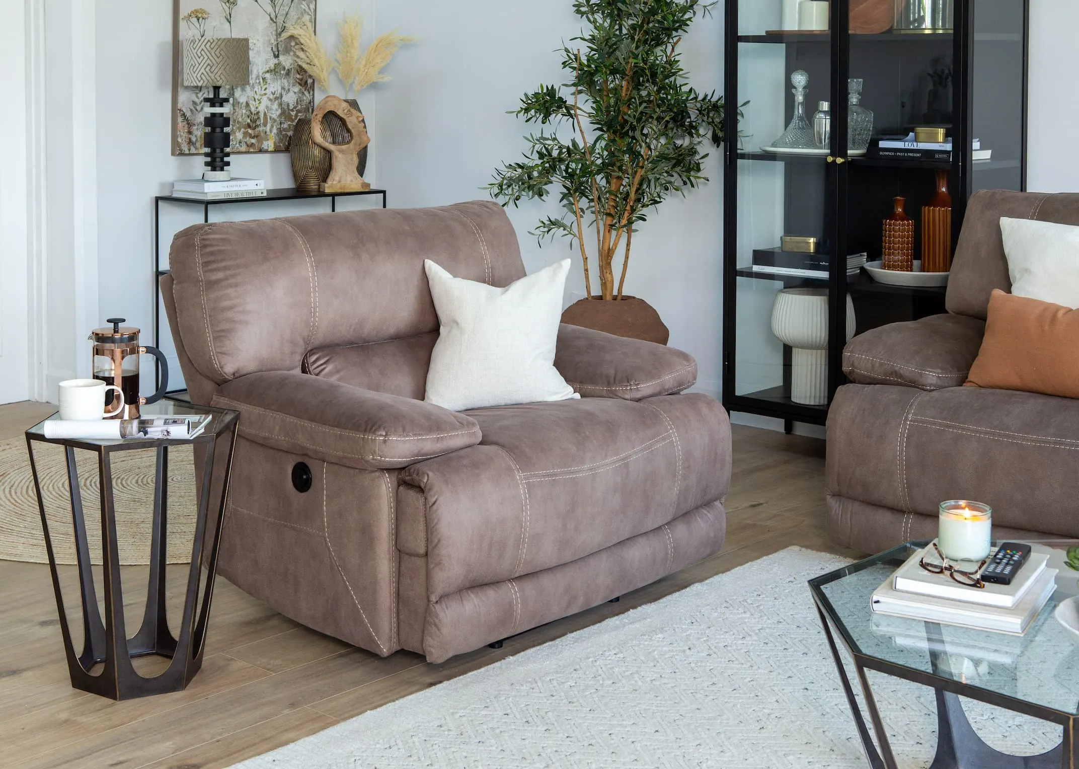 A lifestyle imange of the Baxter taupe recliner in recline mode with catalan tables and Tones of grey canvas.