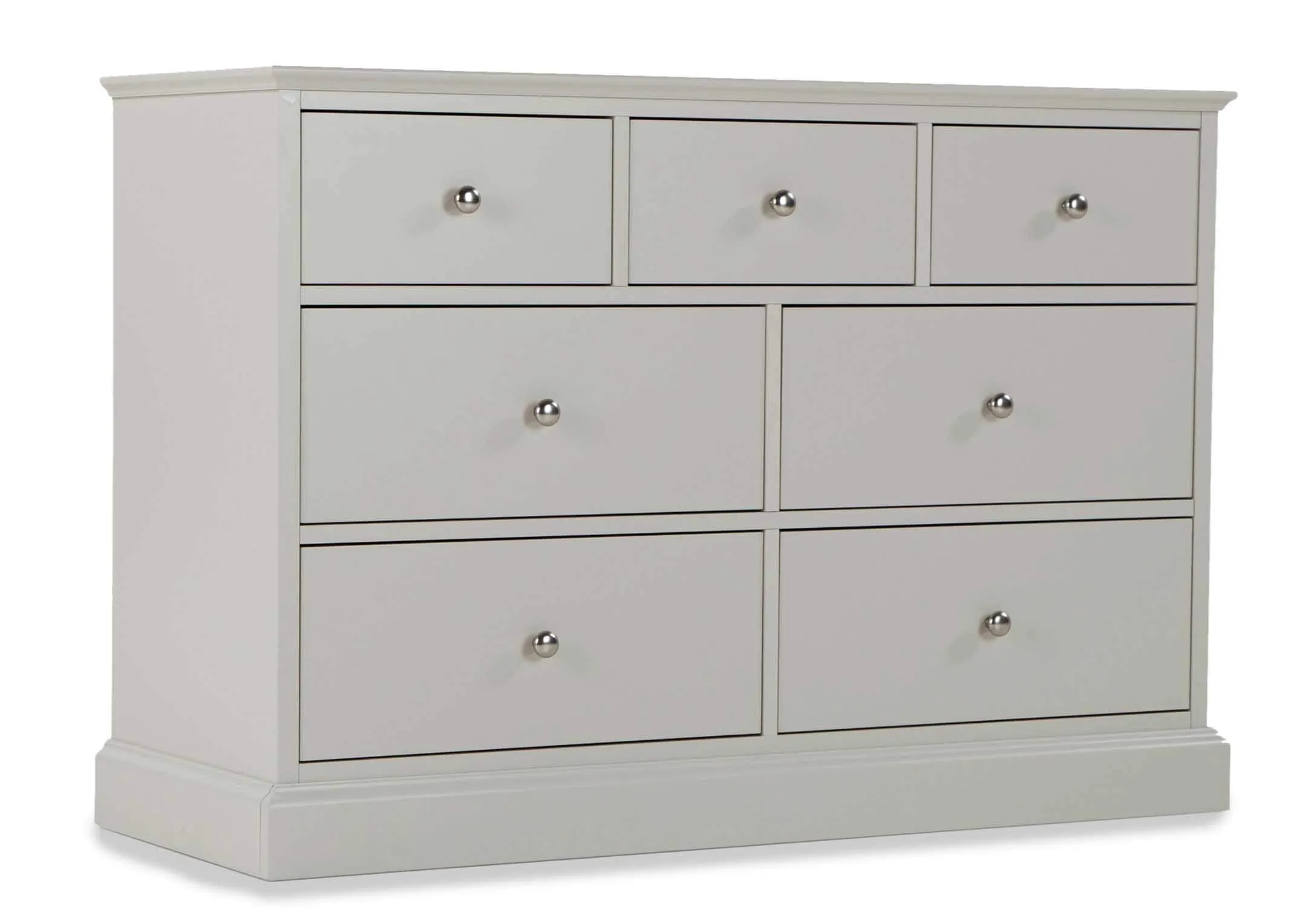 Angled shot of the Rivendale three over four grey chest of drawers with small circular metal handles