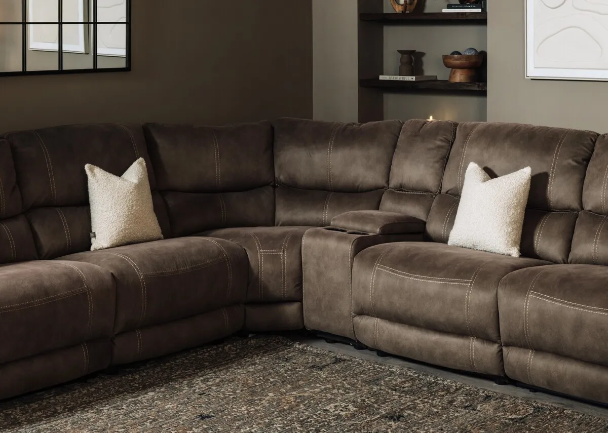 A lifestyle image with a closeup on the modeular parts that can be added to make the sofa larger and sold separately.