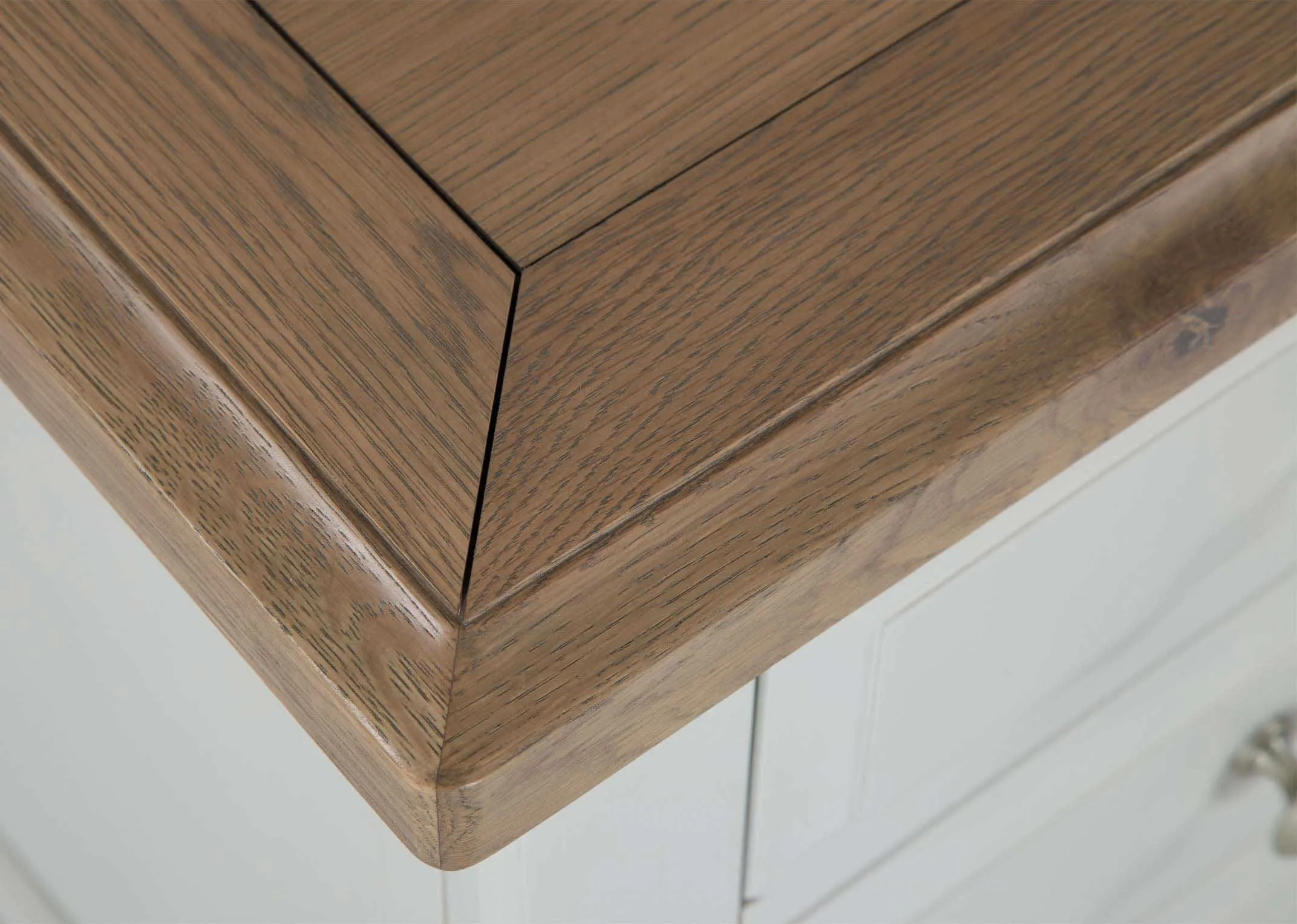 Detailed view of front of three-drawer grey oak bedside locker with light-coloured wooden top Georgia