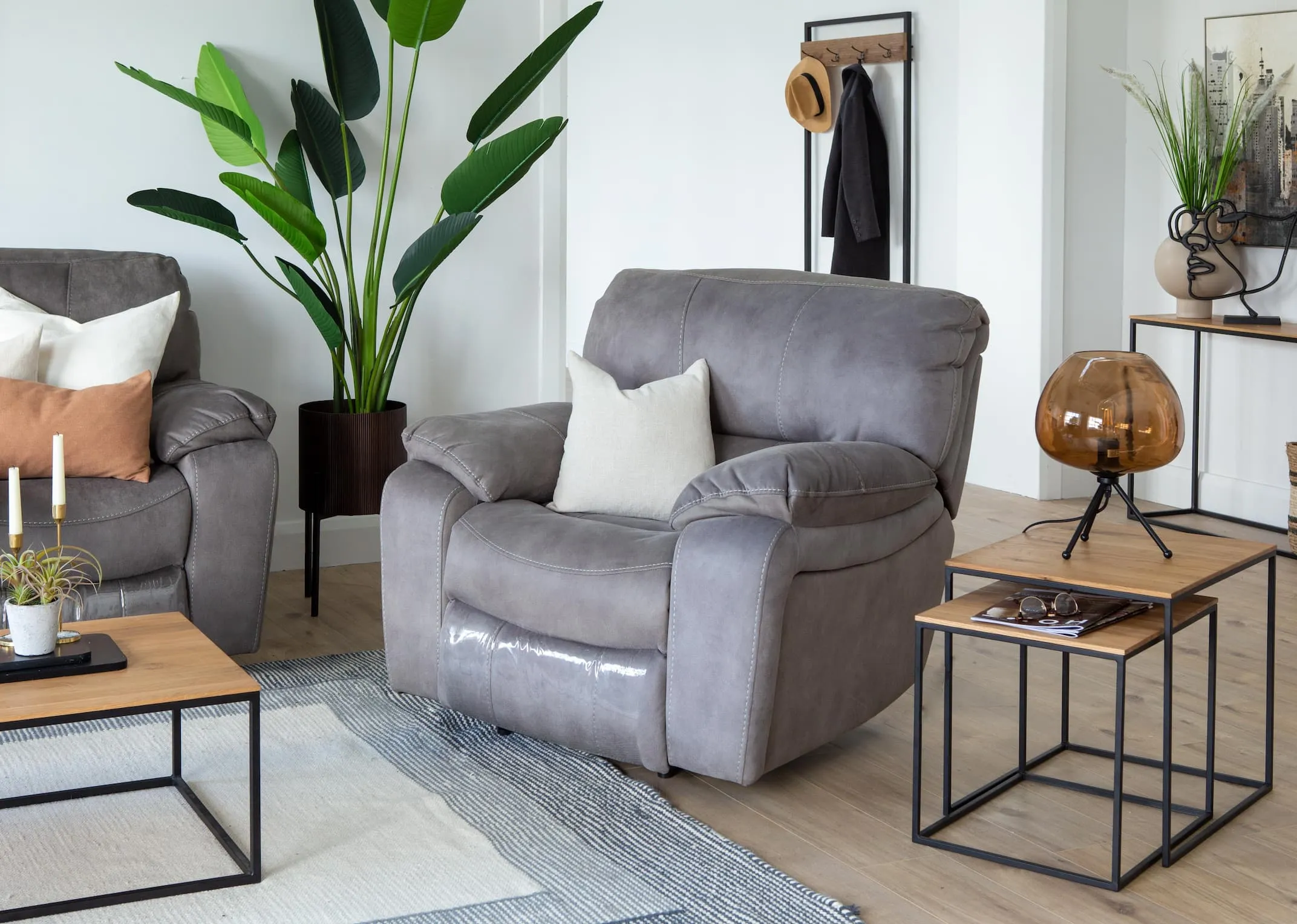A lifestyle image of the Bradford grey armchair with the Aston tables & Mellan floor lamp