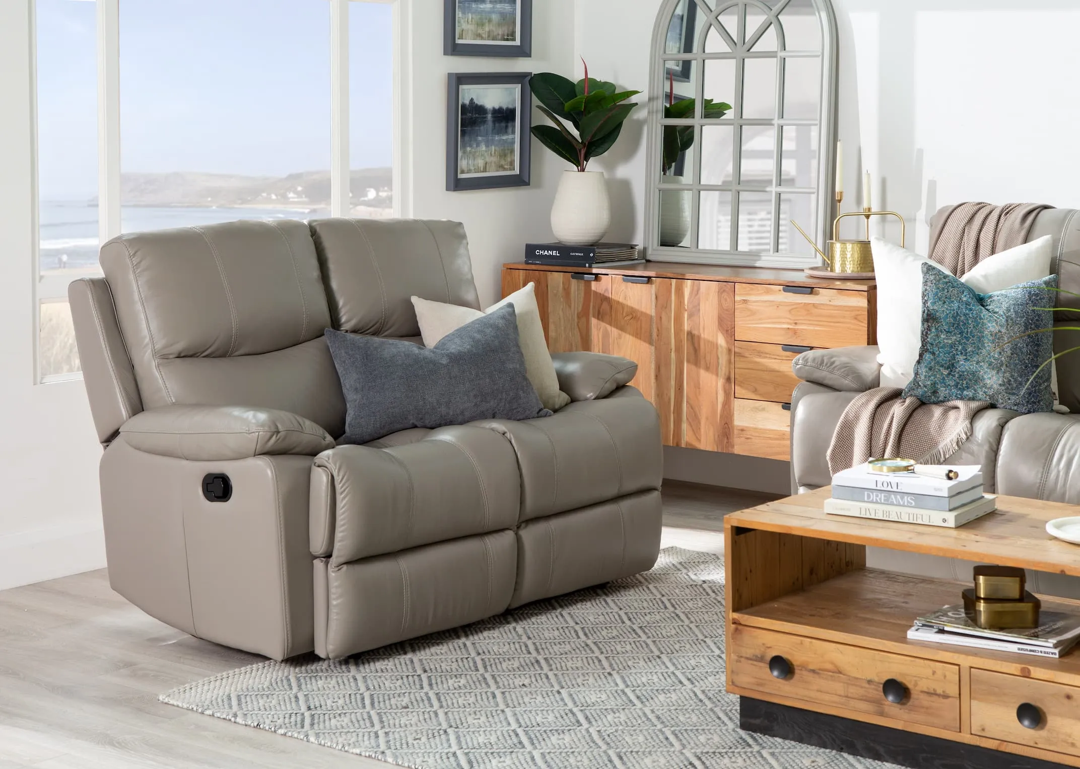 A lifestyle image of the 2 seater Groove grey leather recliner with San Fran living in fixed mode.