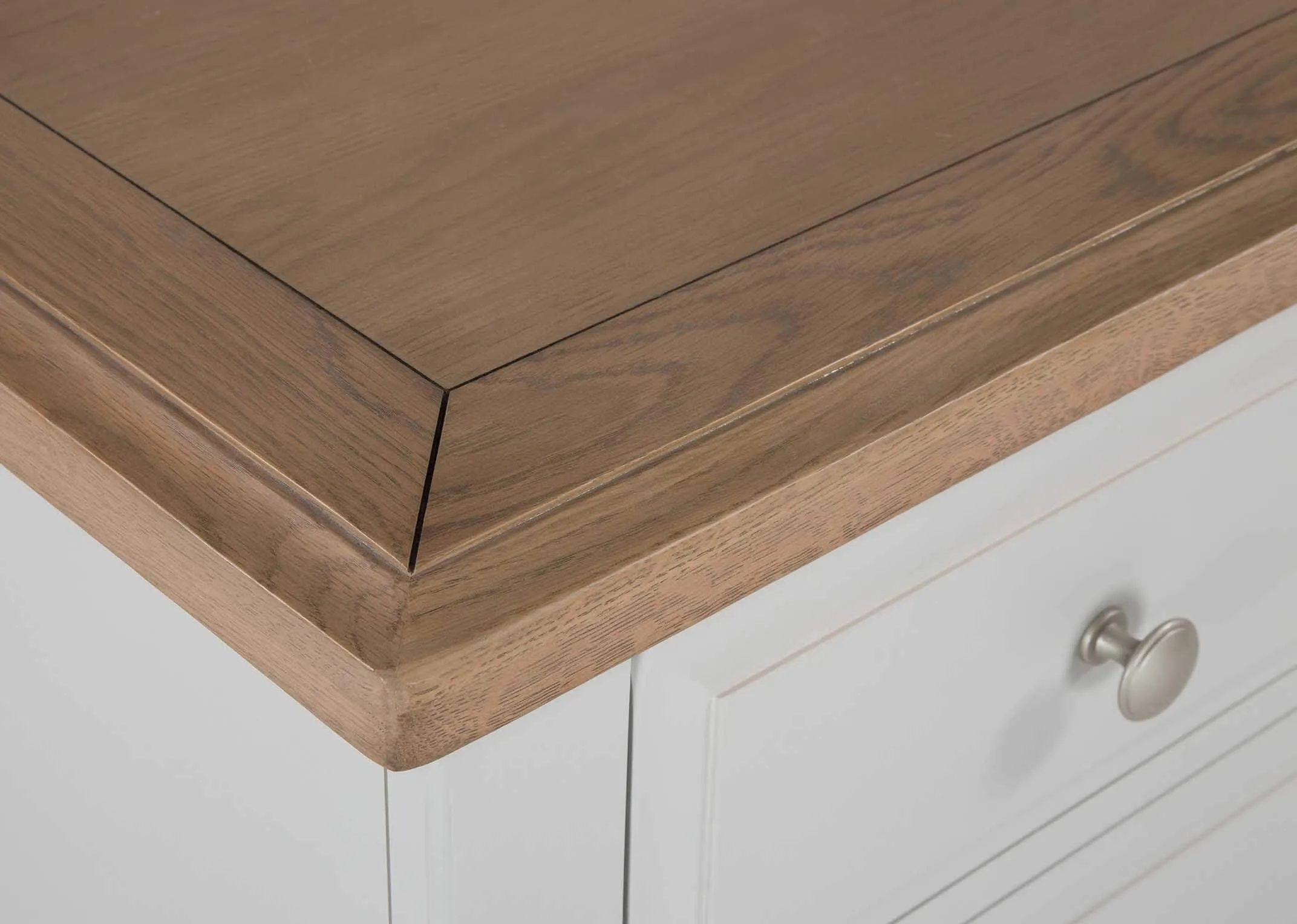 Corner top detail of two over three grey oak Georgia chest of drawers with metallic handles