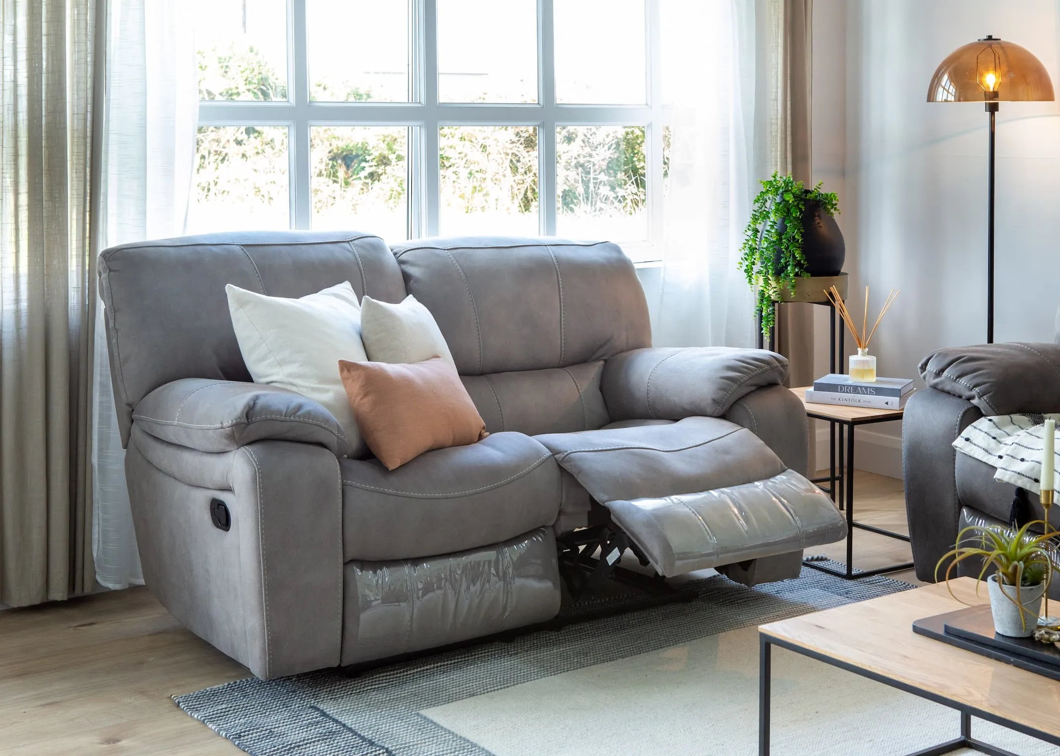 A lifestyle image of the Bradford 2 Seater sofa reclined with the Aston tables.