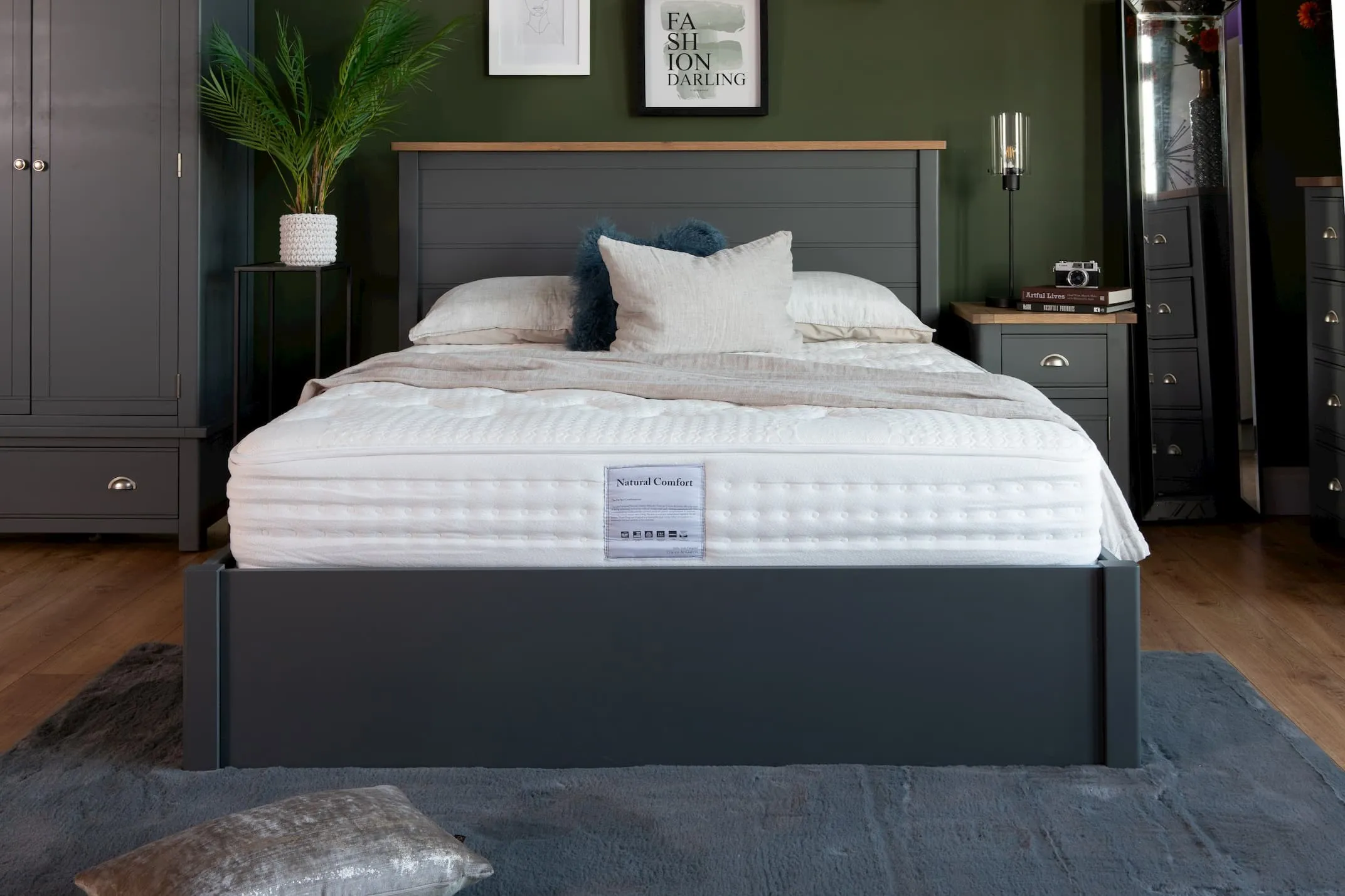 A lifestyle image for the Natural Comfort mattress in a bedroom setting with salmon pillow case and throw. 