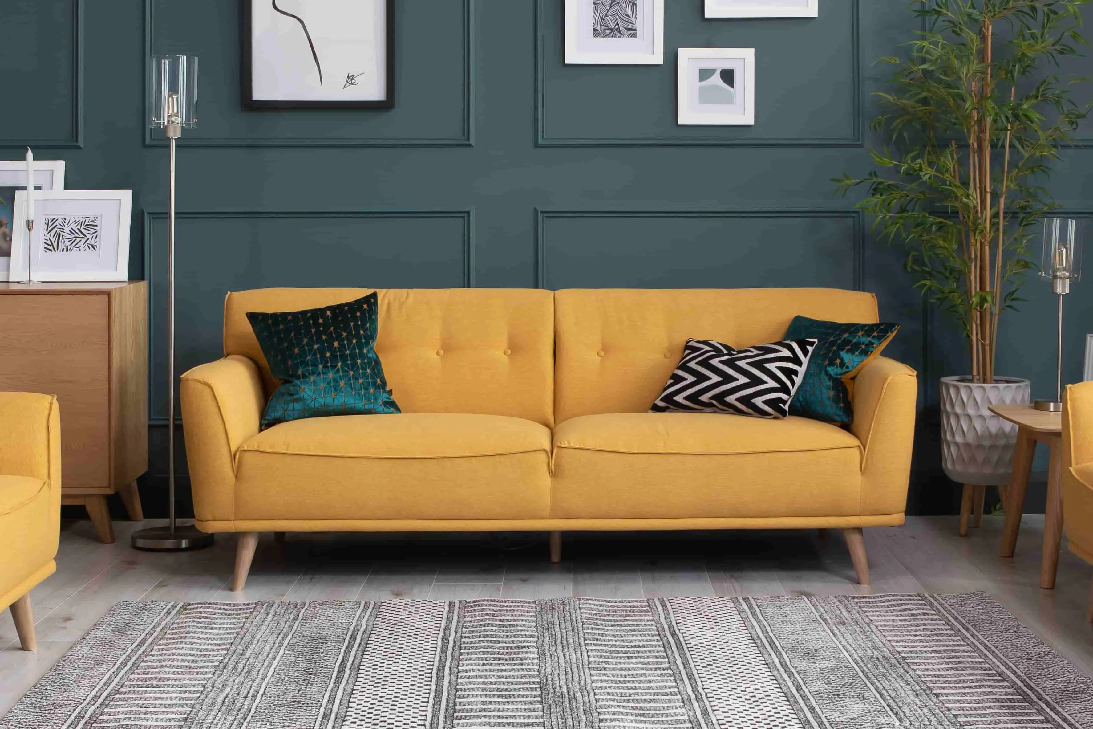 A lifestyle image of the Capri Mustard 3 Seater with Aztec Rug & Leanne Floor lamp