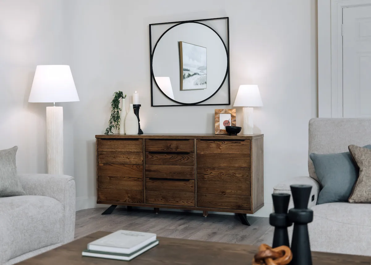 A lifestyle image of the Arno smoked sideboard with Lyle mirror and Elodie lamps
