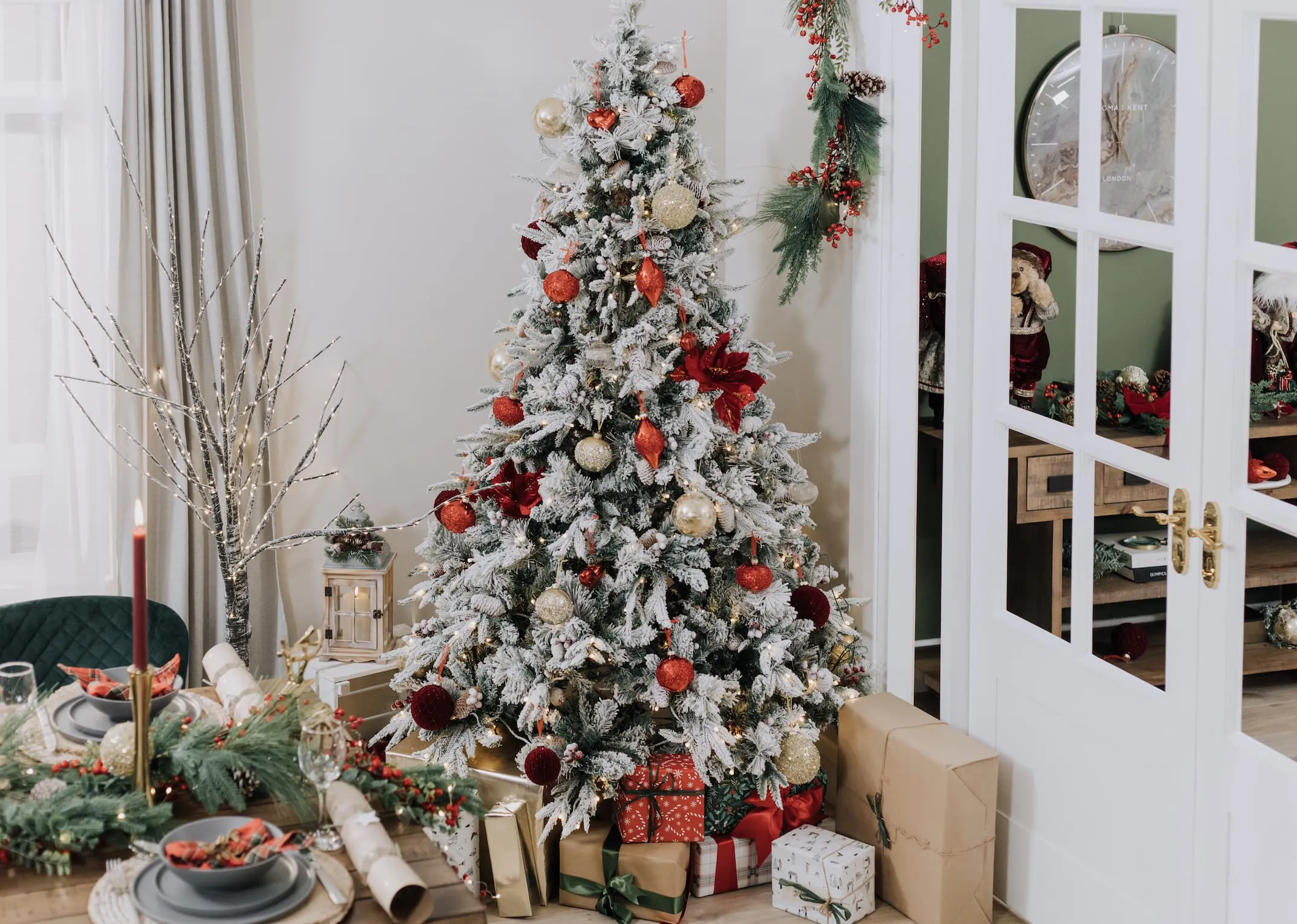 A lifestyle image of the Vermont white Christmas tree with red baubles in a polygon dining room.