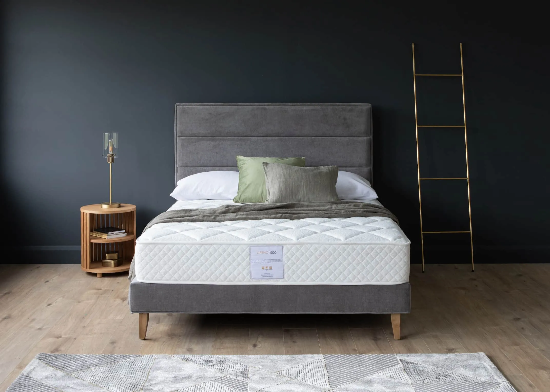 A lifestyle image of the Ebony grey bed base with headboard with an Ortho 1000 mattress & recap night stand.