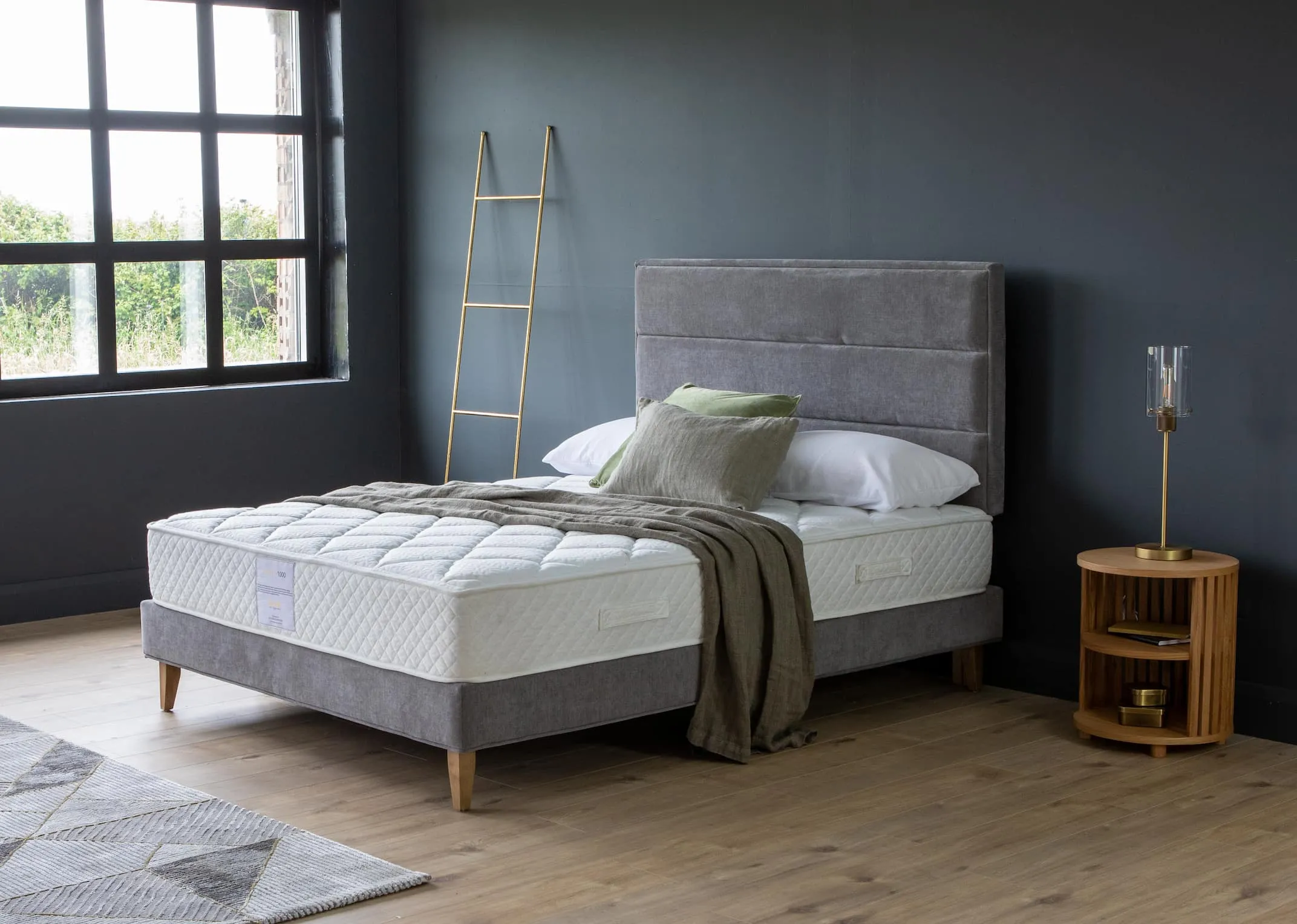 A lifestyle image of the Ebony grey bed base with headboard with an Ortho 1000 mattress & recap night stand.