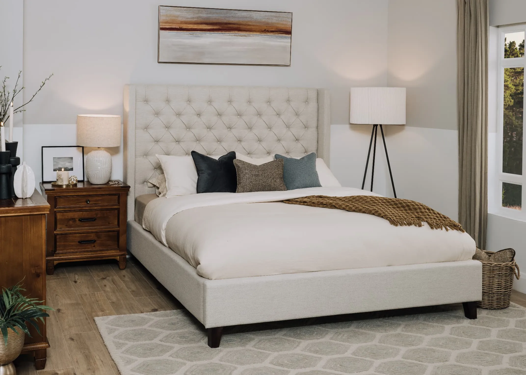 A lifestyle image of the Enhance Bed with evening glow canvas ove the headboard with Allyson side locker and chest.
