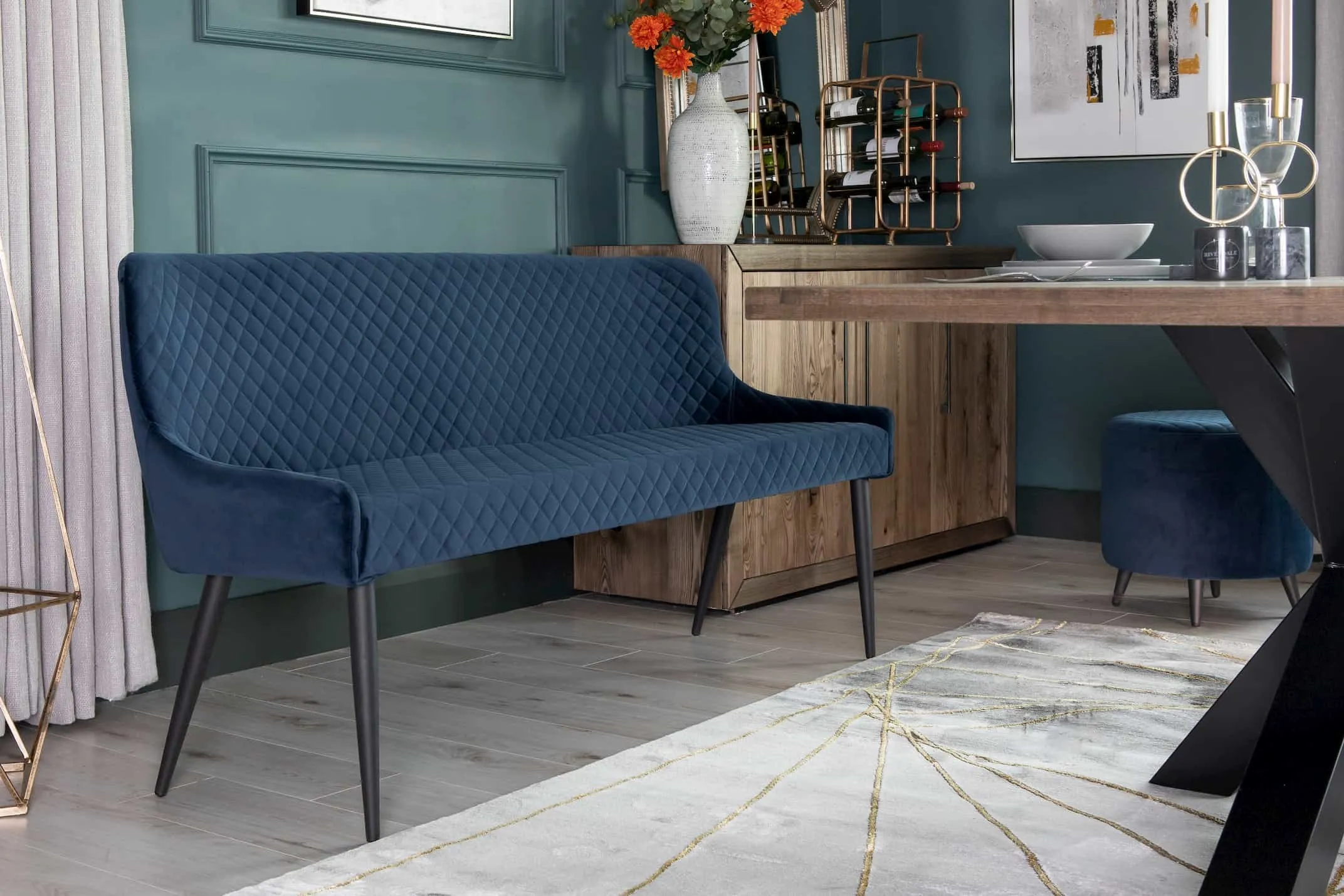 A lifestyle image of the Ottowa Dining bench with back in blue with the Smoked Forest Furniture & Avery rug