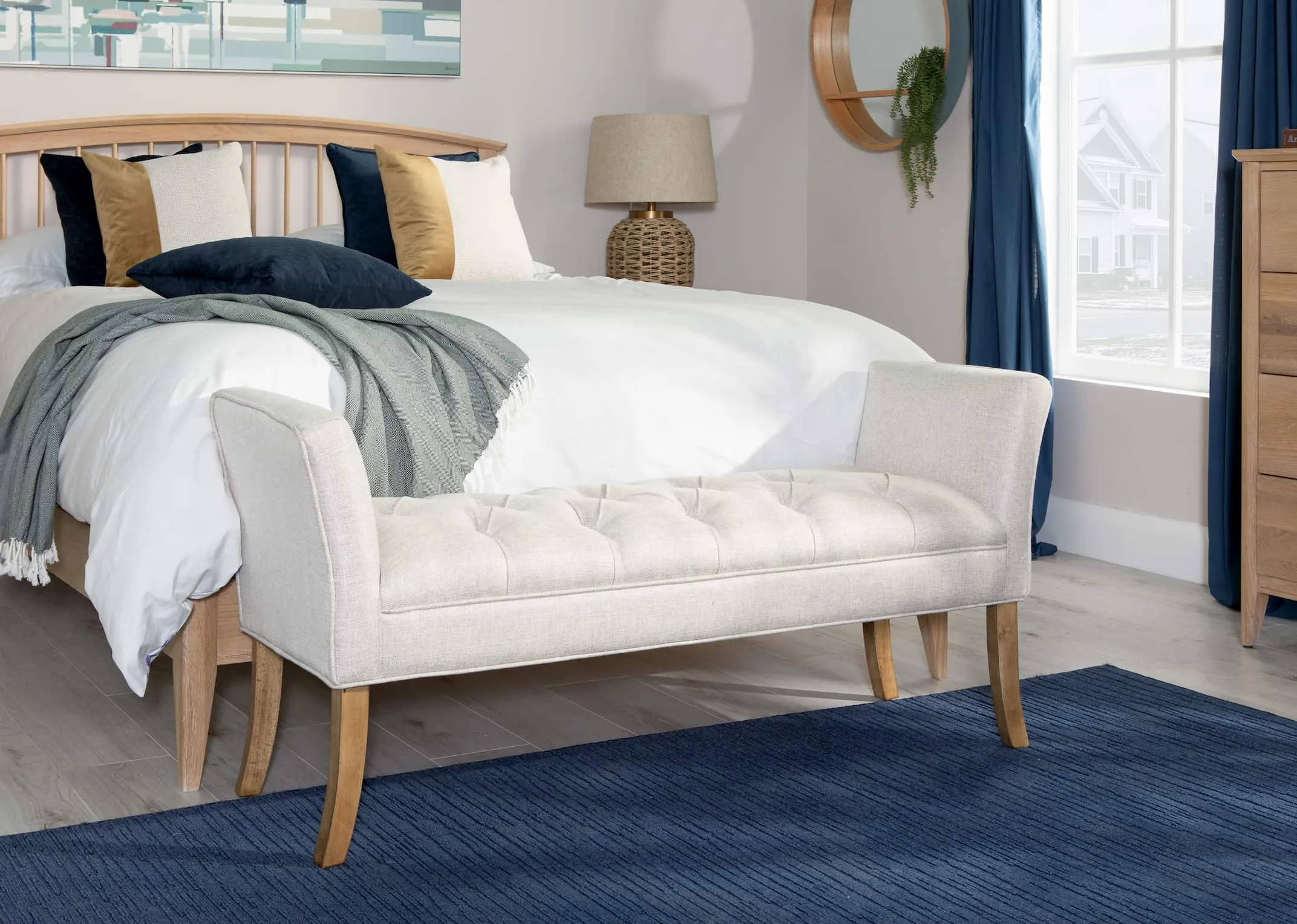 A lifestyle image of the Cancun Silver Bench set at the bottom of the Arc Bed frame with Donna lamp & Odil mirror