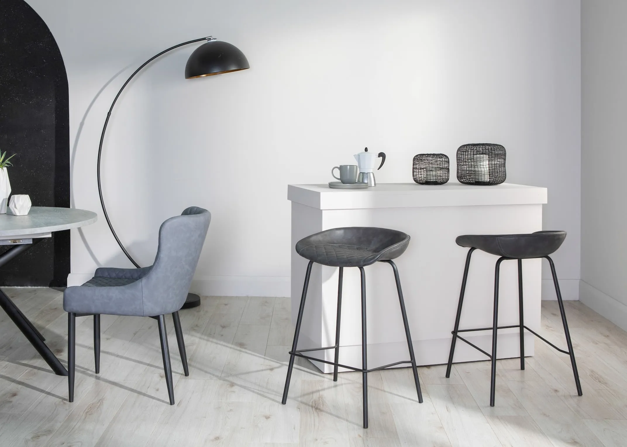 A lifestyle image for the Jensen Grey Stool with Ottowa chair with skoop hurricane lanterns