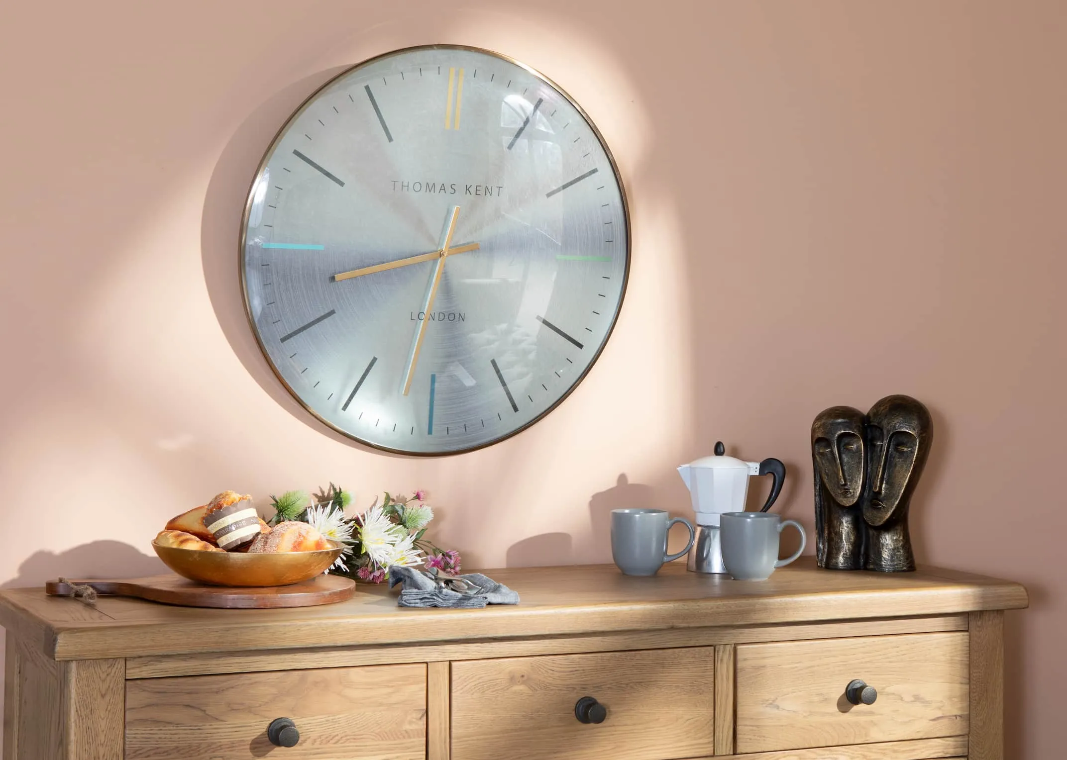 A lifestyle image of the Oyster Clock with Country Cottage Oak Sideboard available to shop at EZ Living Furniture
