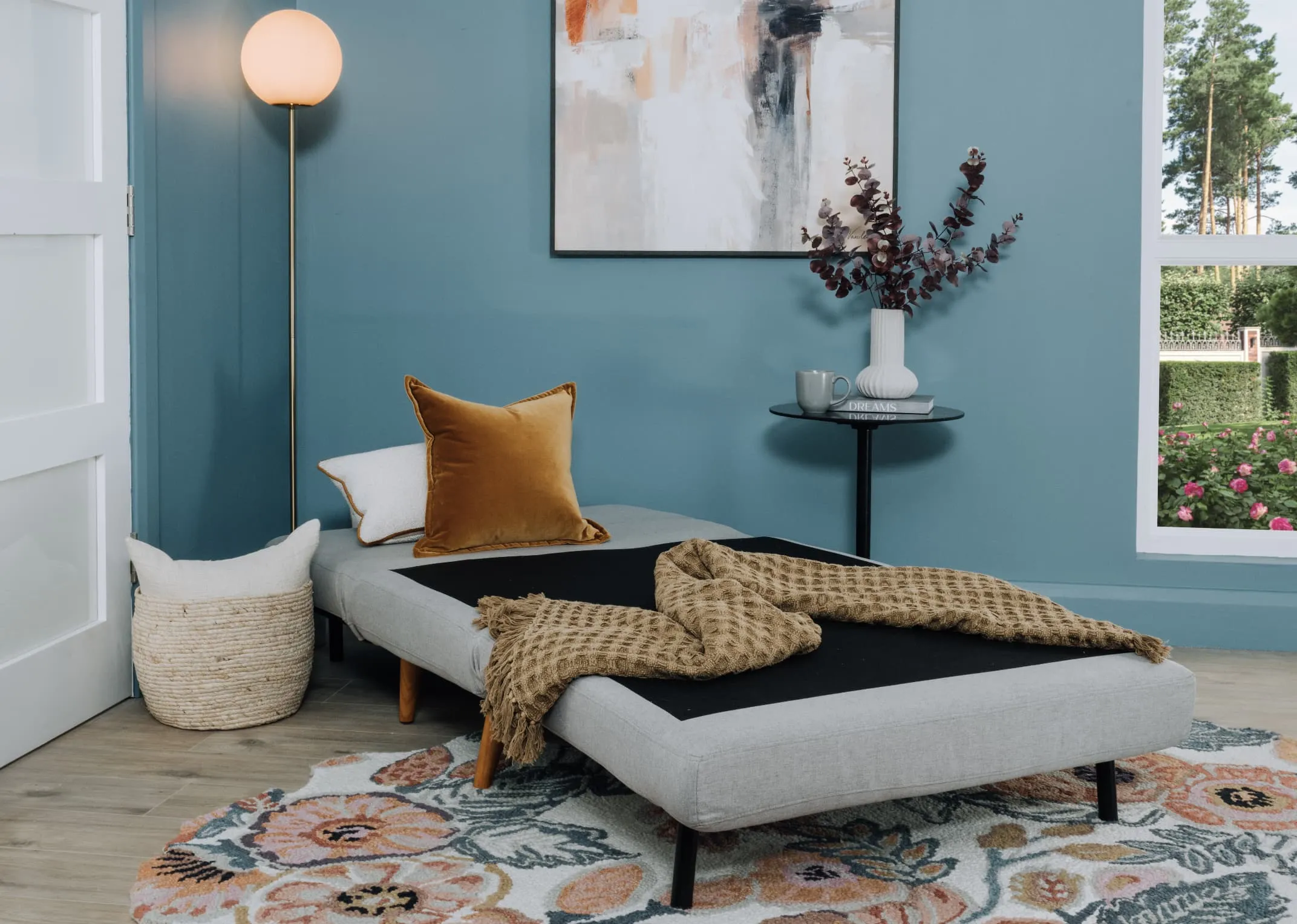 A lifestyle image of the Zara Grey sofa bed as a bed with the Barison rug.
