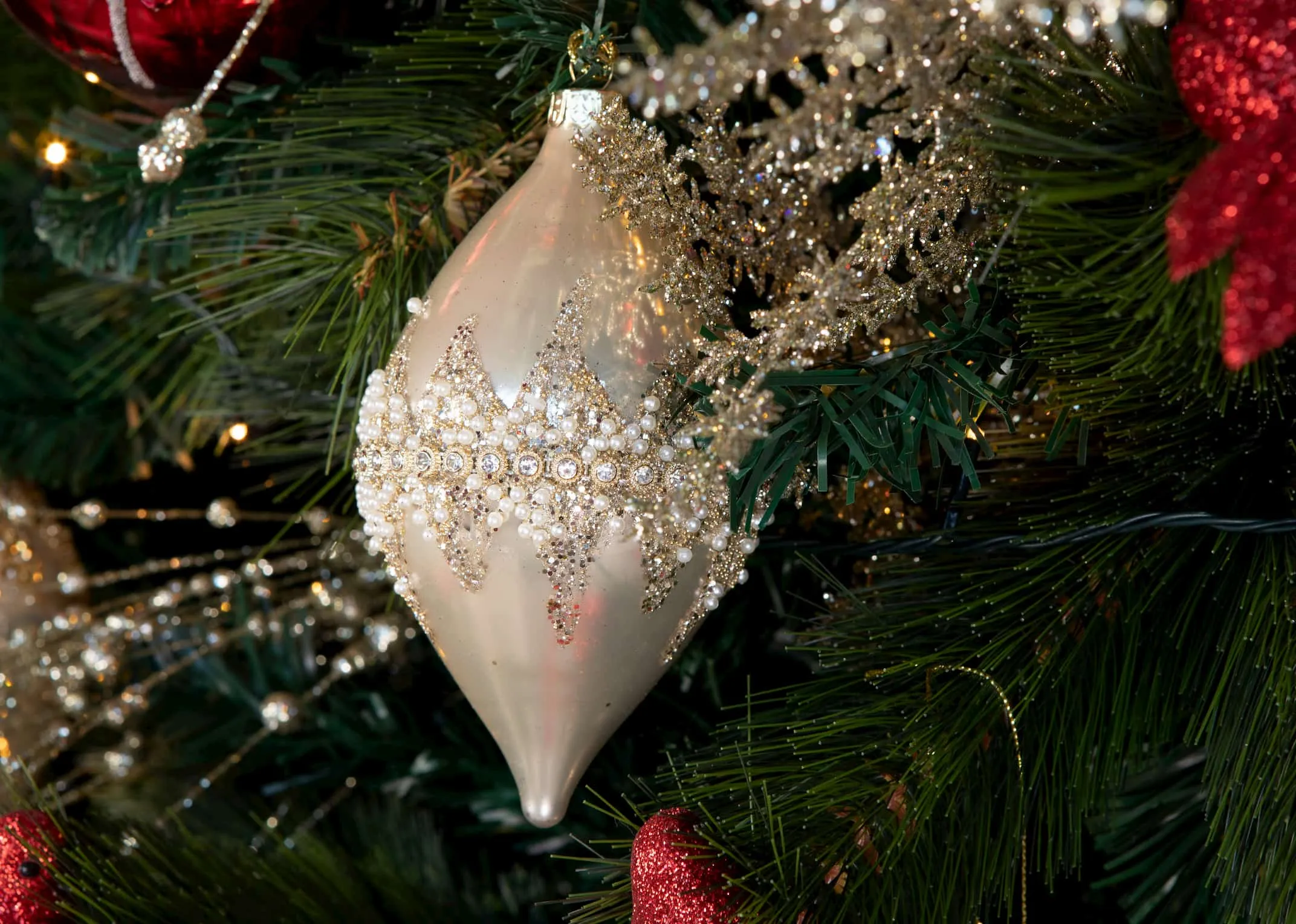 A lifestyle image of the Gold jewel drop bauble on a Christmas Tree available at EZ Living Furniture.