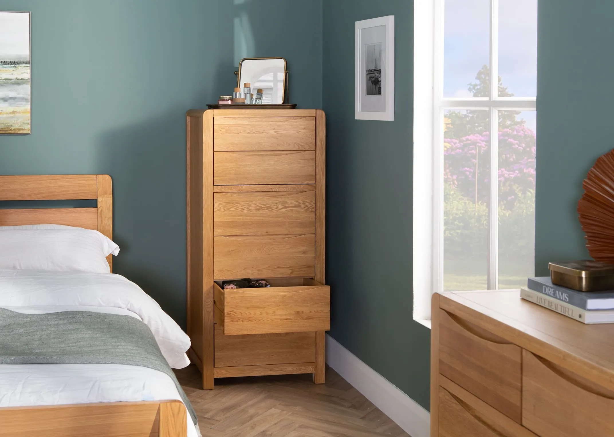 A lifestyle image of the Iris bedroom with bed & tallboy with last drawer open showing space
