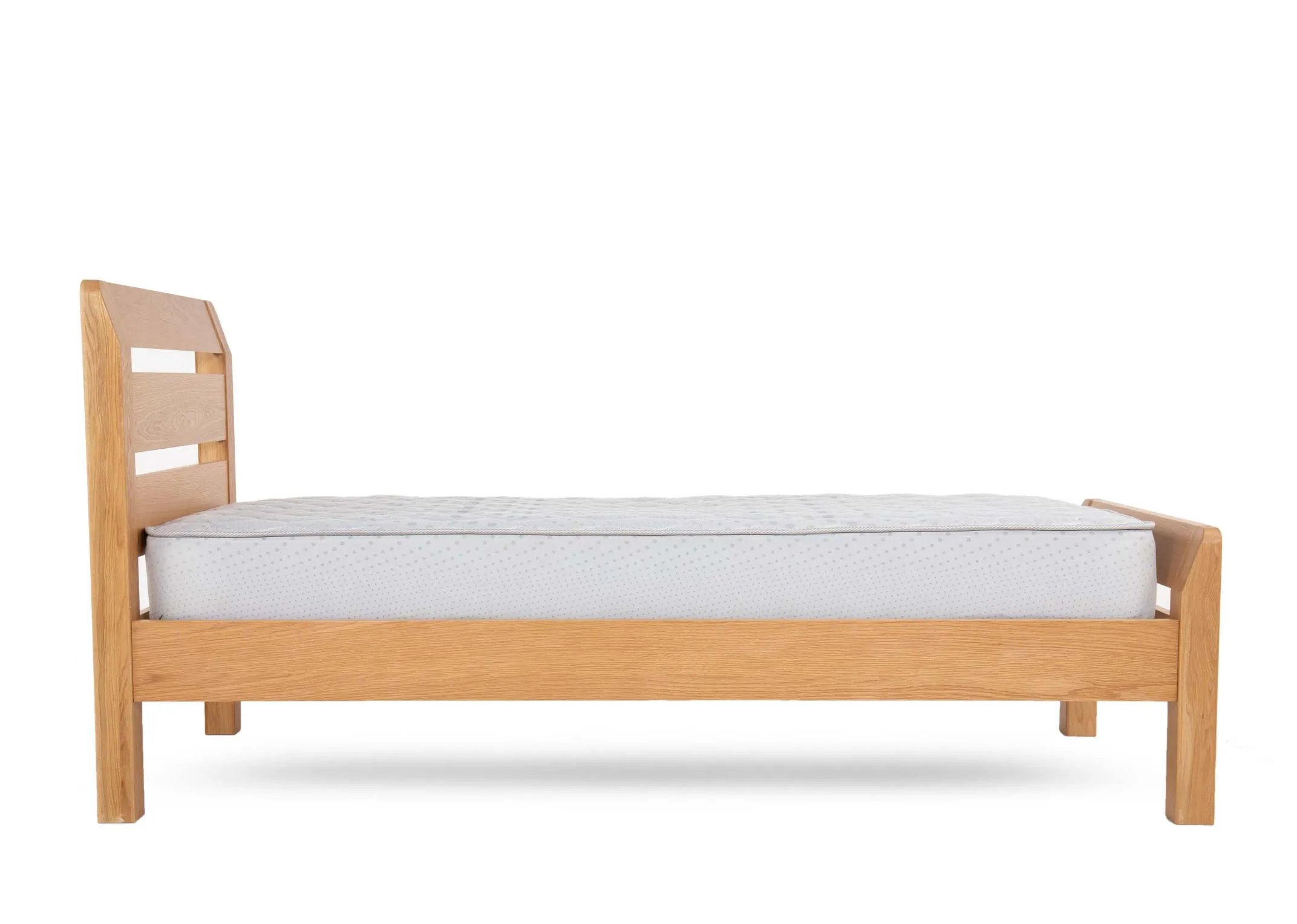 An oak 3ft single bedframe from EZ Livings Iris range. Side view of small feet and low footboard