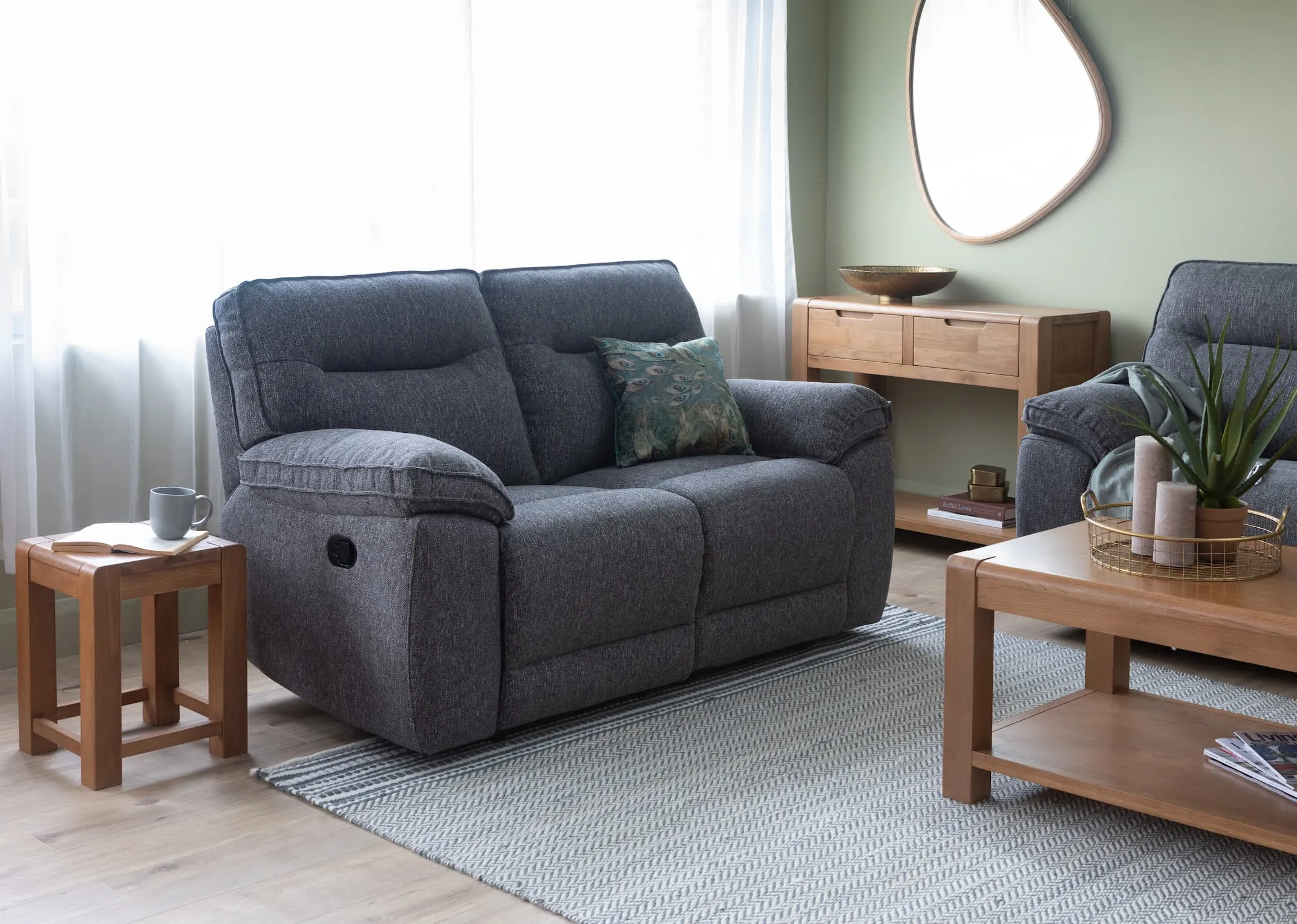 A lifestyle image of the Cairms Grey Fabric 2 Seater with Tiverton lamp