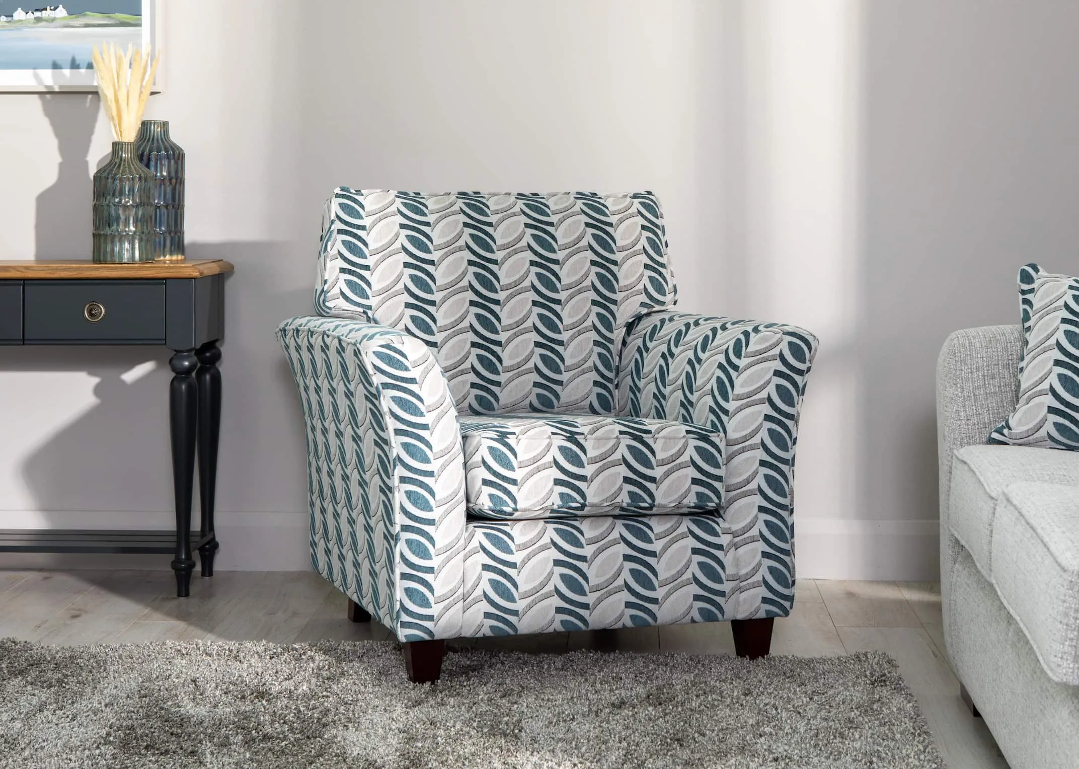 A lifestyle image of the Kilronan Armchair & sofa with oberon rug & toulouse console table.