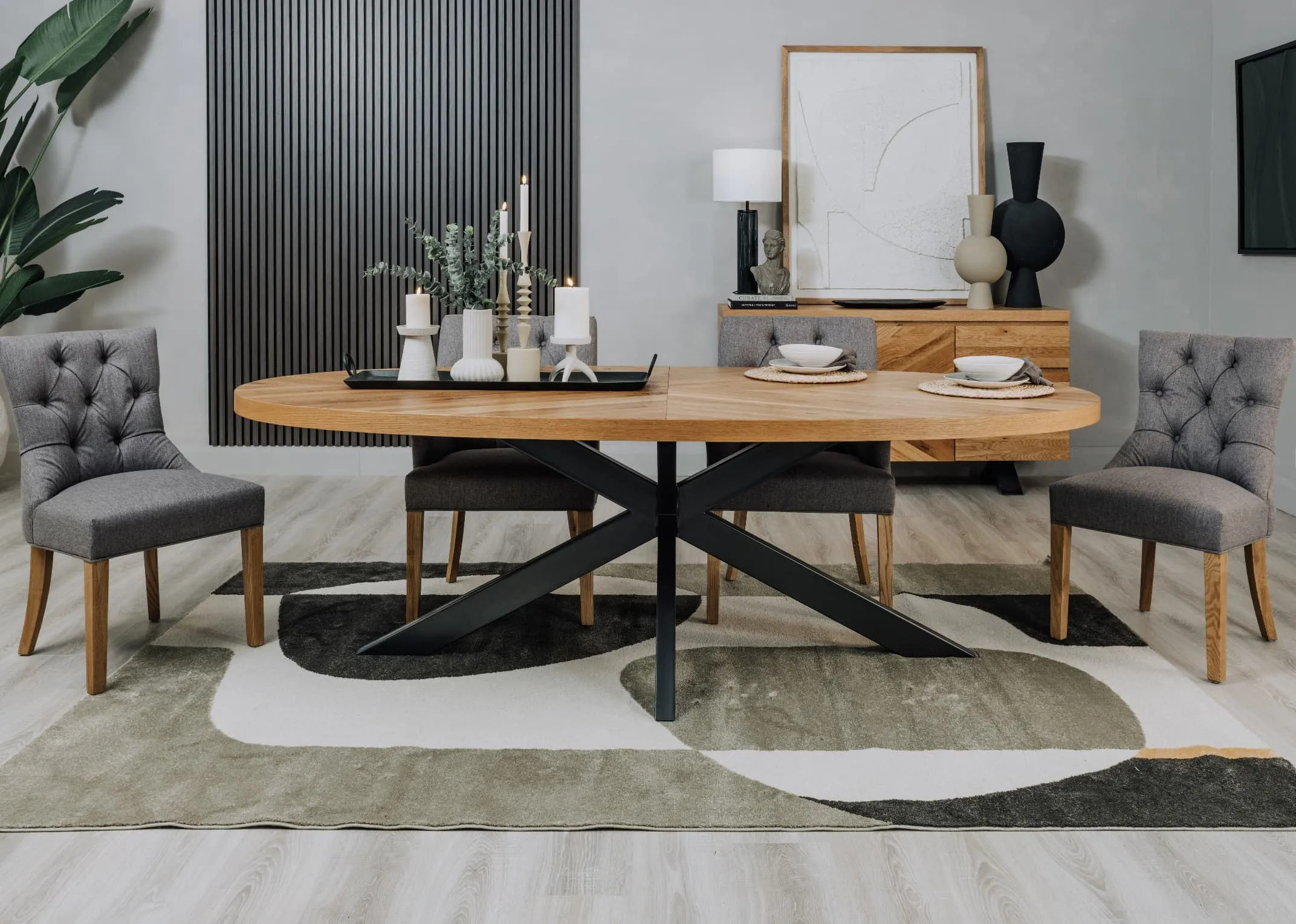 A lifestyle image of the Ellipse oval dining table with Felix grey carver and dining chairs with Bree rug
