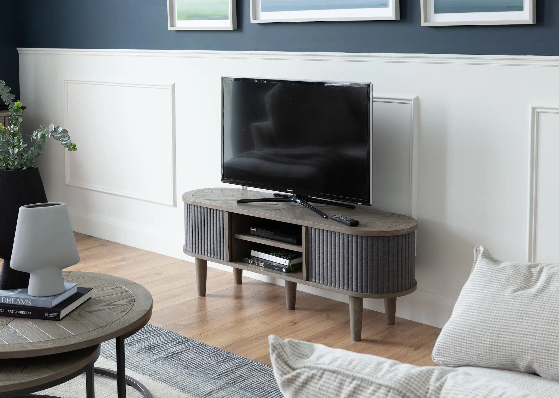 A lifestyle image of the Strata sofa with Monroe tv unit with tv & nest of coffee tables from EZ Living Furniture