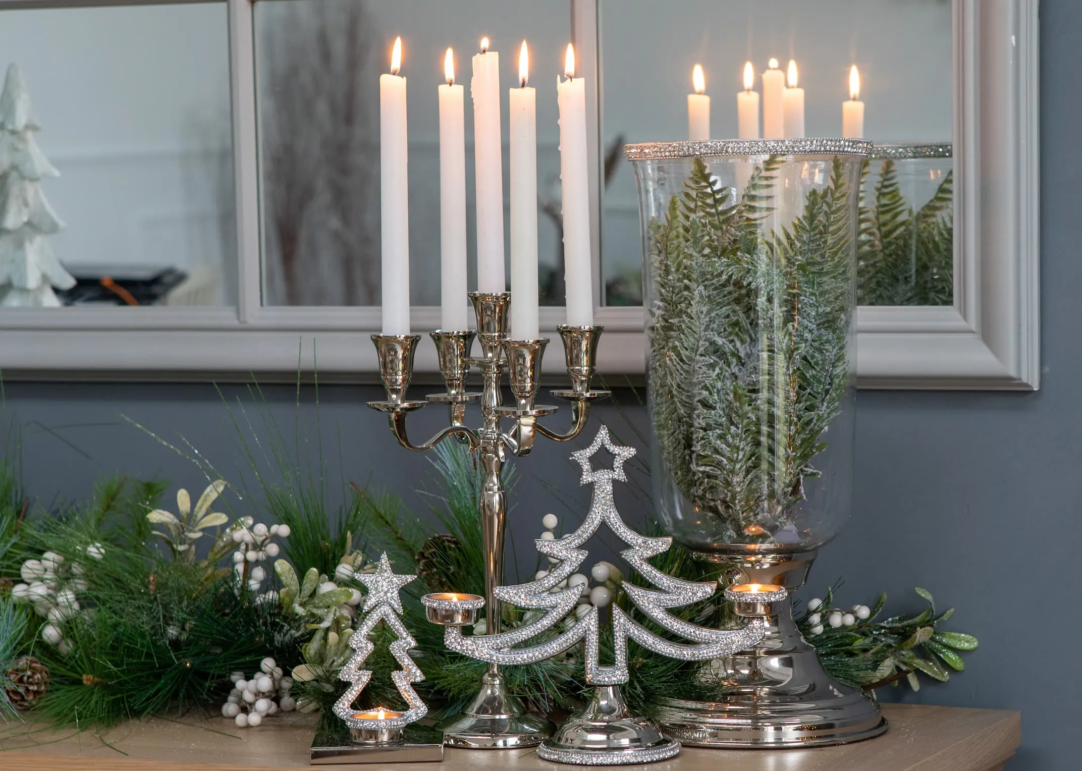 A lifestyle image of the Multi Stick Candleholder with Rhinestone Xmas Trees & Clear Glass Vase with base.