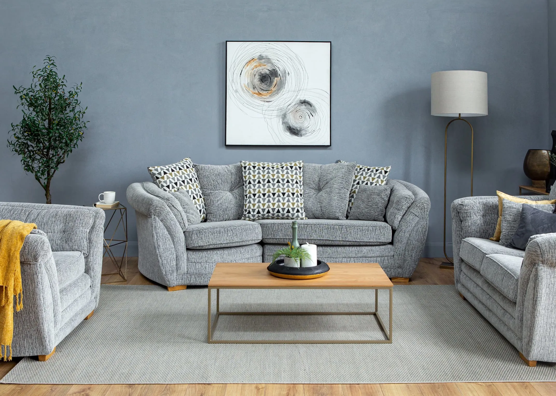 A lifestyle image of the Isaac Snuggler with Isaline rug & Olive tree in pot