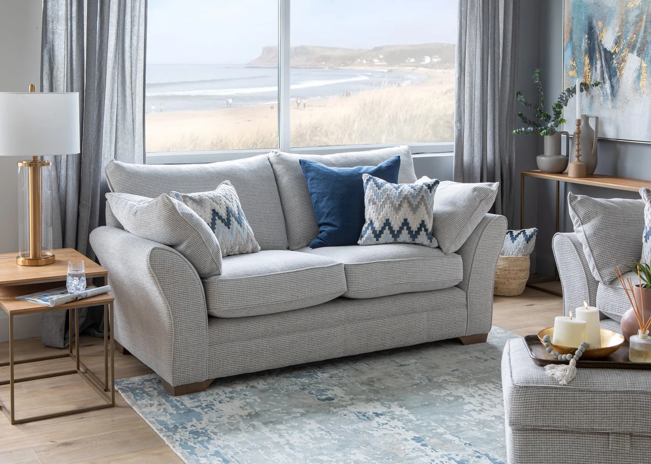 A lifestyle image of the Strata 2 seaterwith footstool and aspen tables