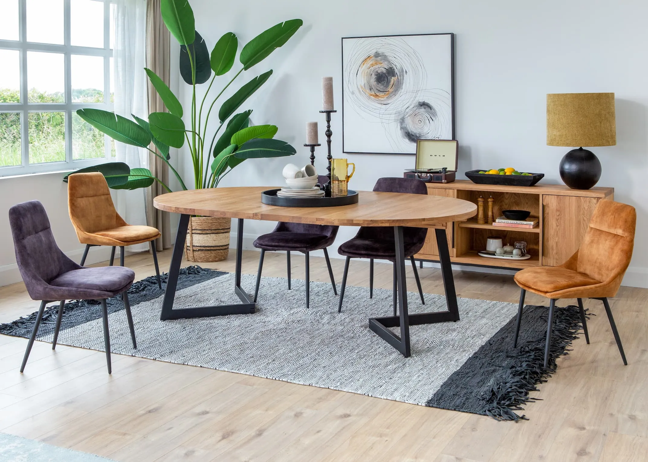 A lifestyle image of the Renvyle table fully extended paired with Bohemian chairs and Renvyle sideboard