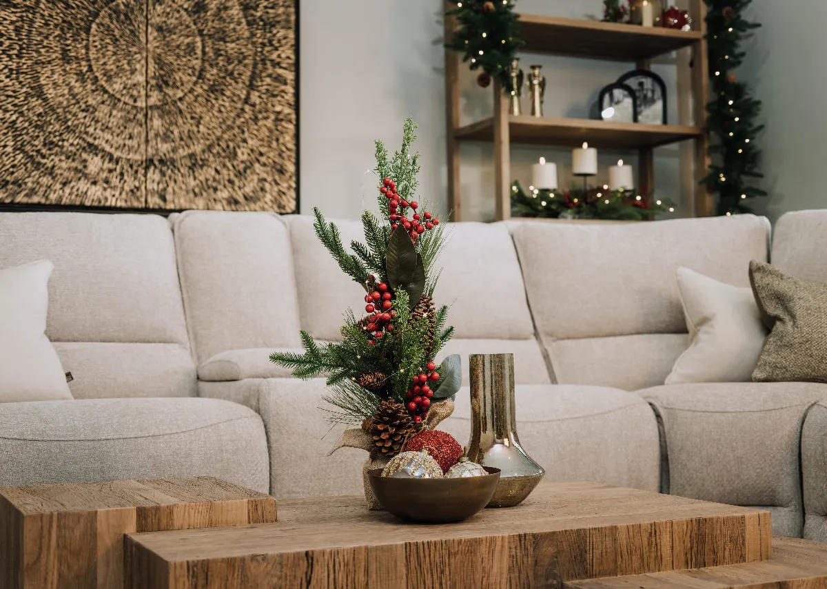 A lifestyle image of the Ashbrook sofa with Nova coffee table with vase & berry & pine LED tree.