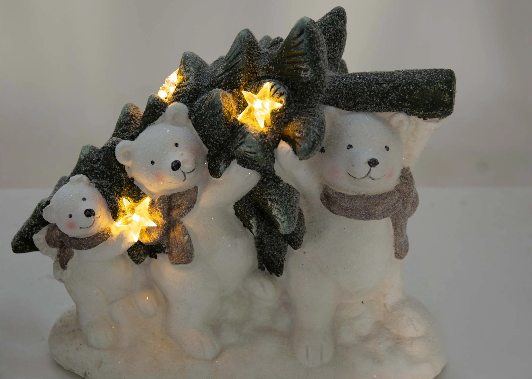 An ornament of three white bears varying in size carrying a tree from the EZ Livings Christmas range. Closeup of led stars lit up
