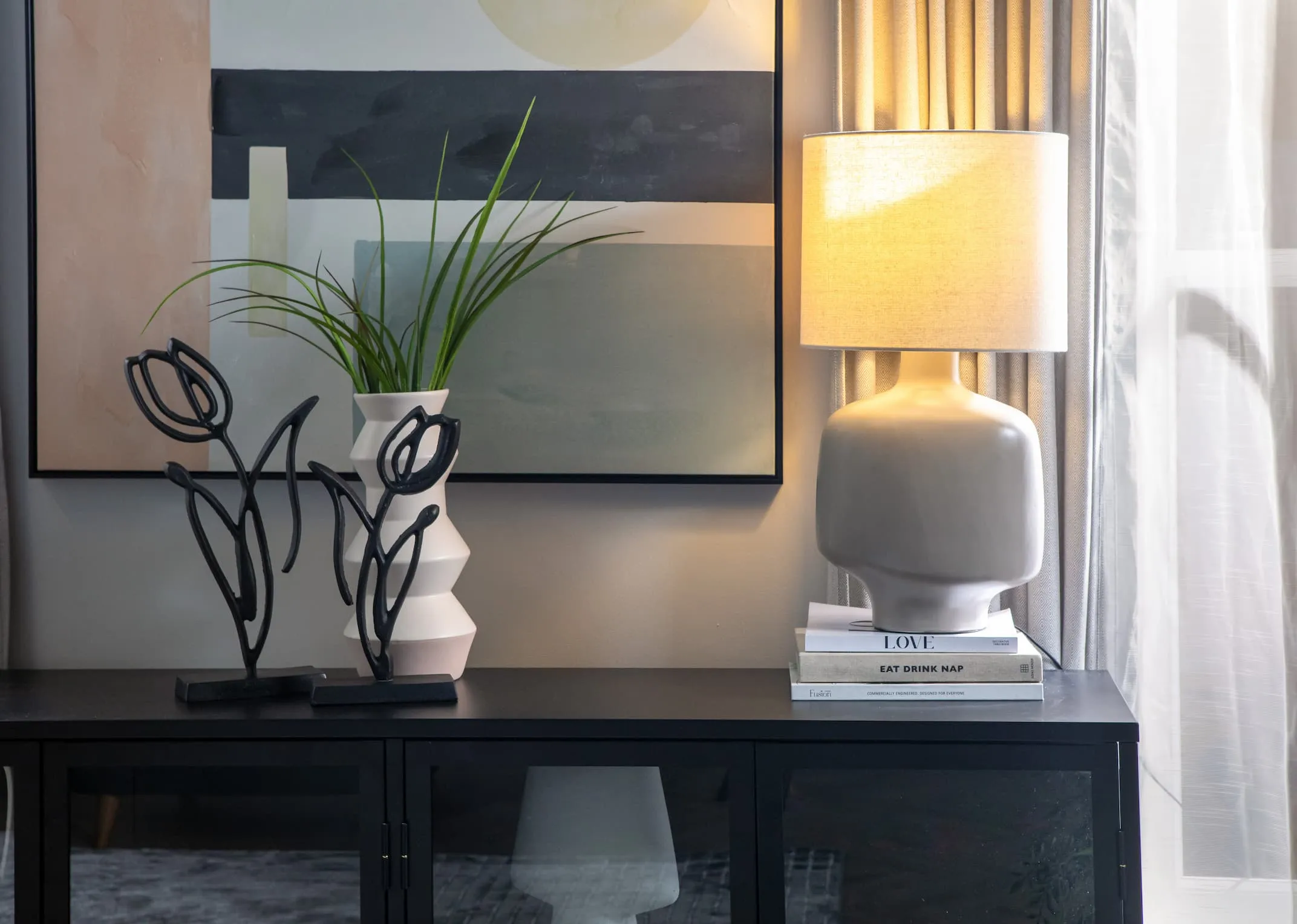 A lifestyle image of the Retro lamp on with Tuplianu ornaments on the Carmel Sideboard.