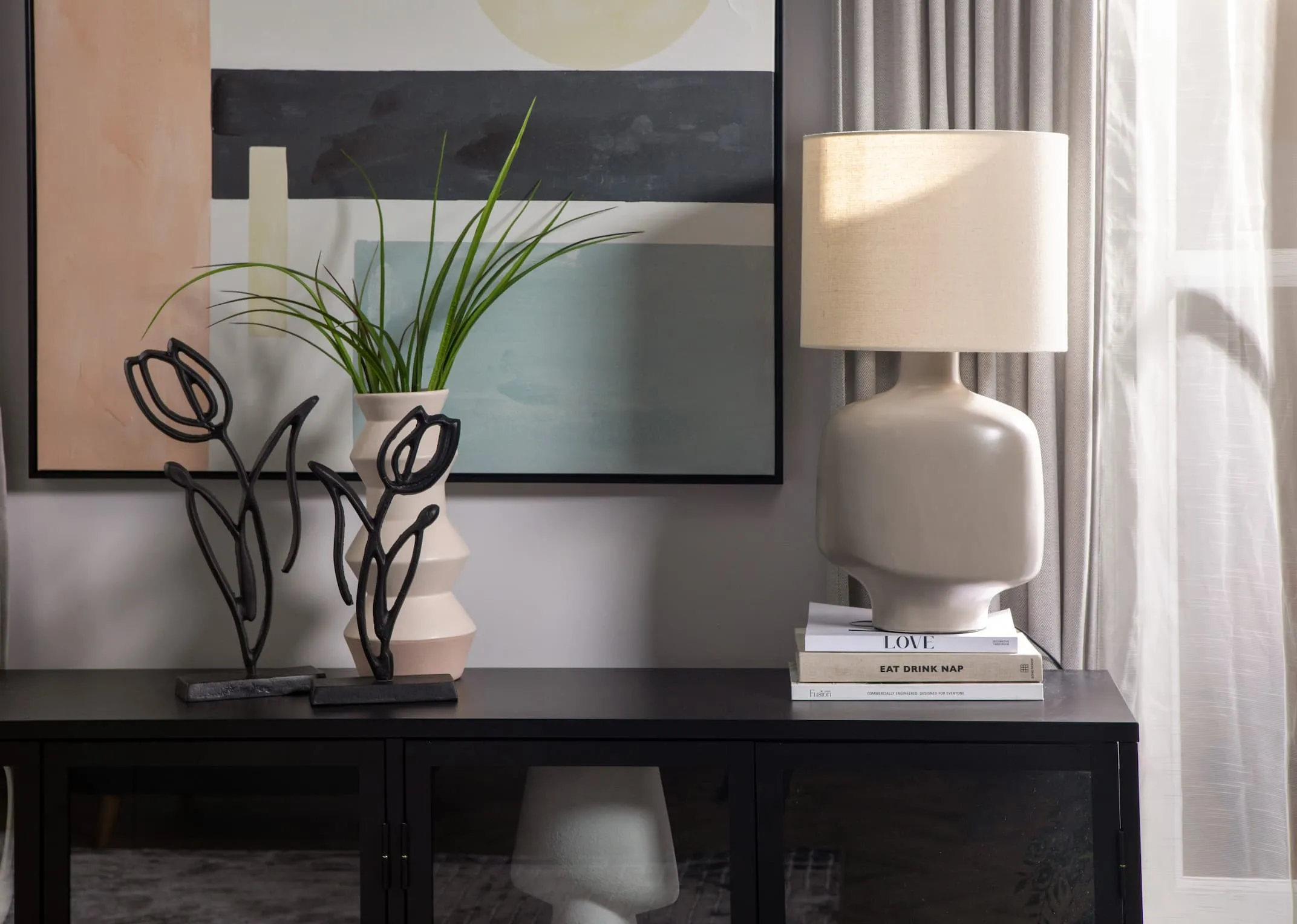 A lifestyle image of the Retro lamp off with Tuplianu ornaments on the Carmel Sideboard.