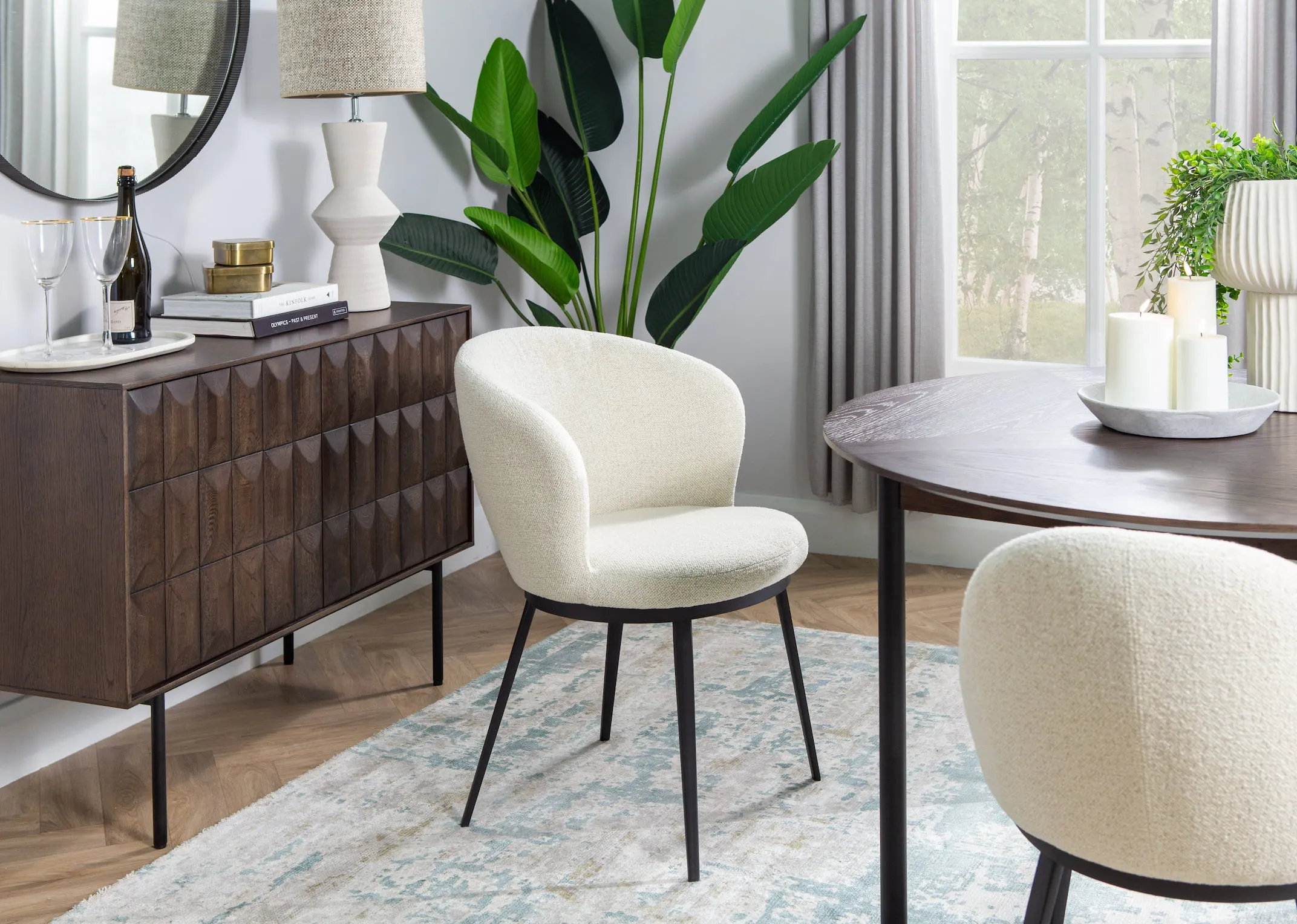A lifestyle image of the Boucle Gain carver with Latina sideboard & table.