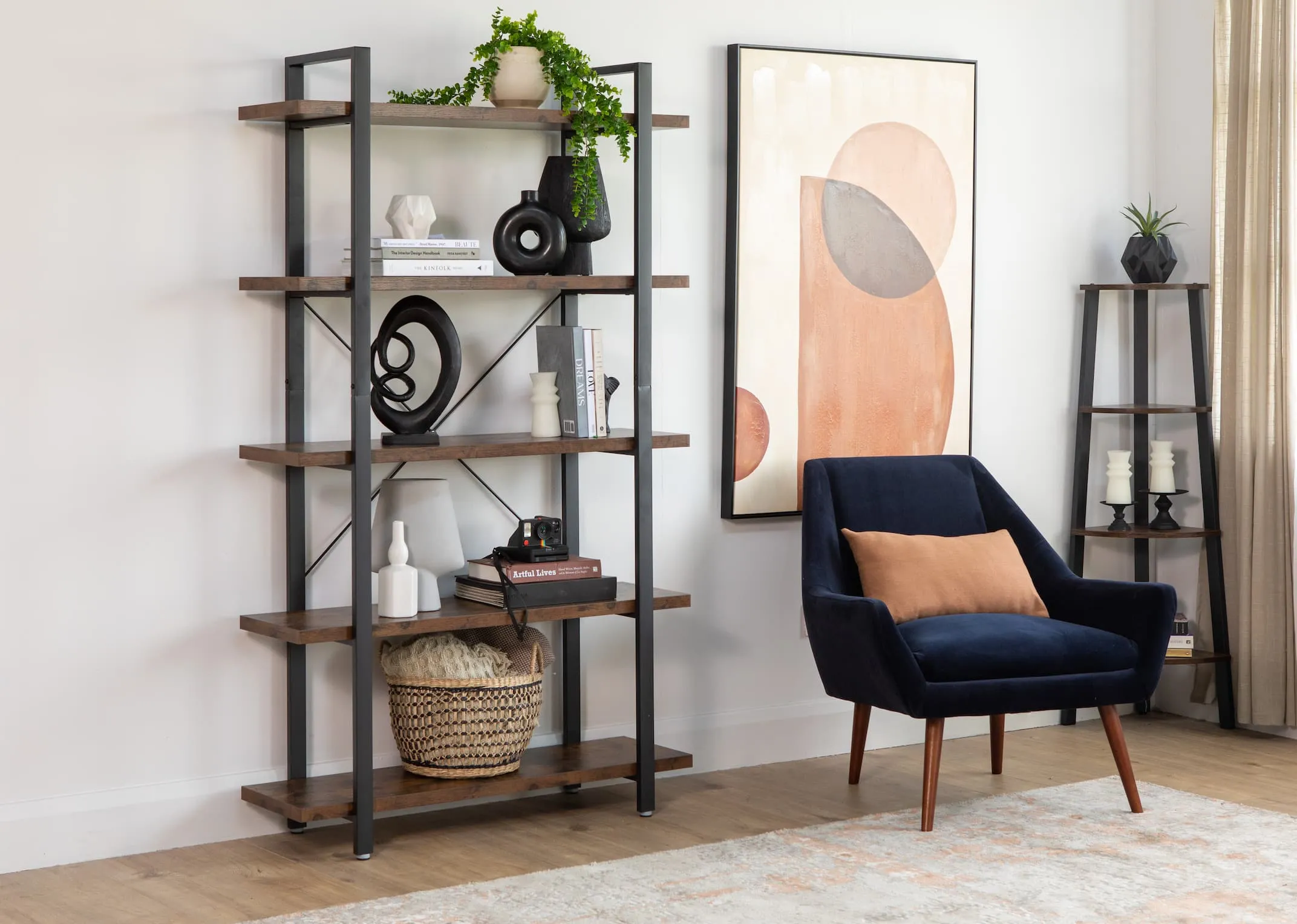 A lifestyle image of the Kenzie Bookcase with a selection of EZ Living Furniture ornaments with Janey chair & Perception canvas
