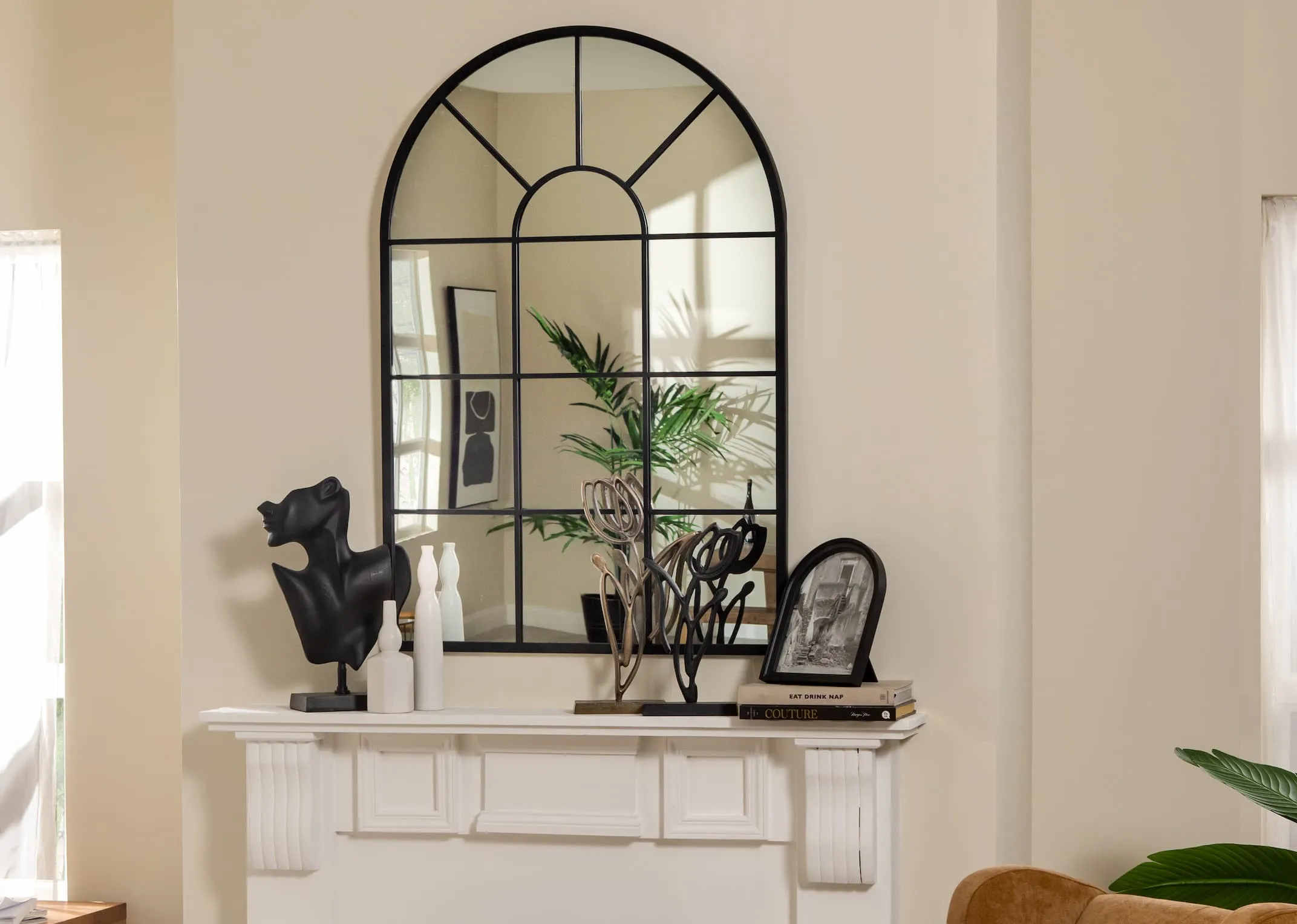 A lifestyle image of the Bella Arch window mirror over a fireplace with tulipanu ornaments & Letta frame.