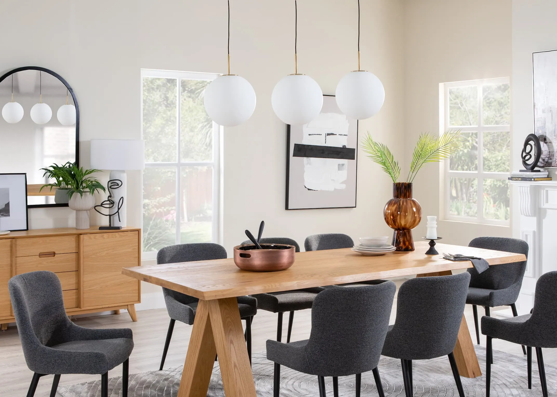 A lifestyle image of the Copenhagen dining table with sideboard and Ontario chairs with the Medina gold & white ceiling lights
