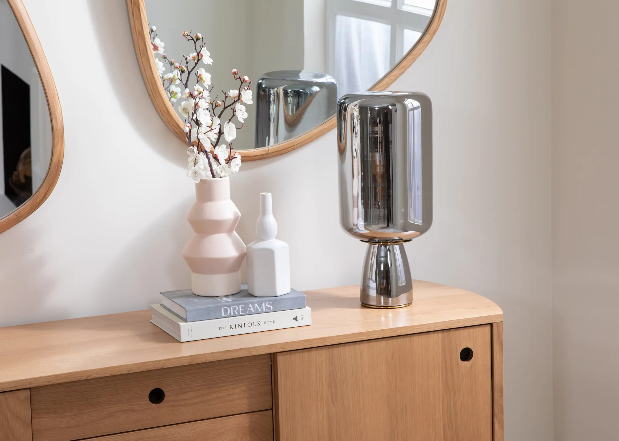 A lifestyle image of the Lotta table lamp switched off with the Copenhagen sideboard and Cody mirror.