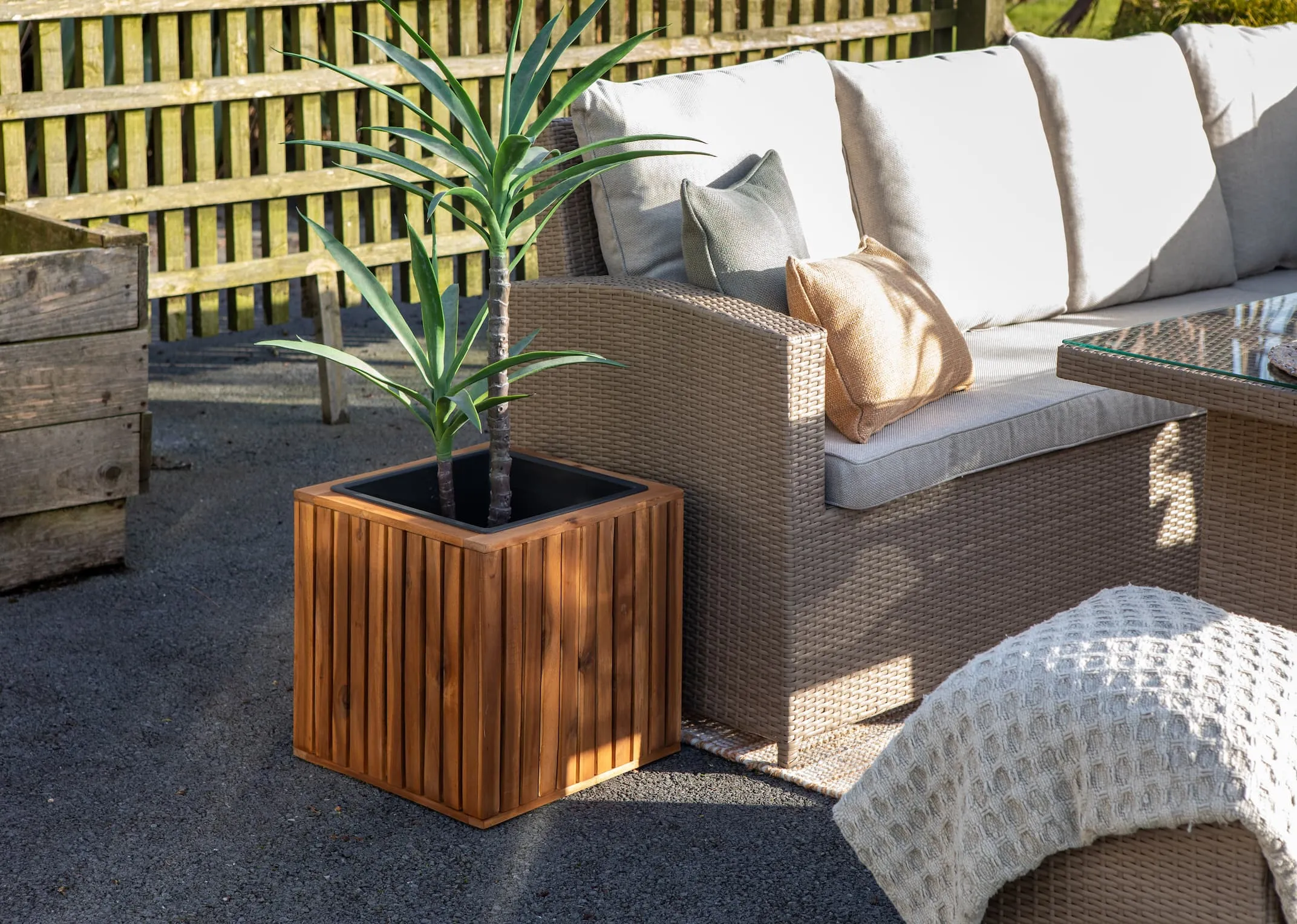 A lifestyle image of the Small Santa Cruz planters with Yucca plant in an Outdoor setting with the Malaga Garden set