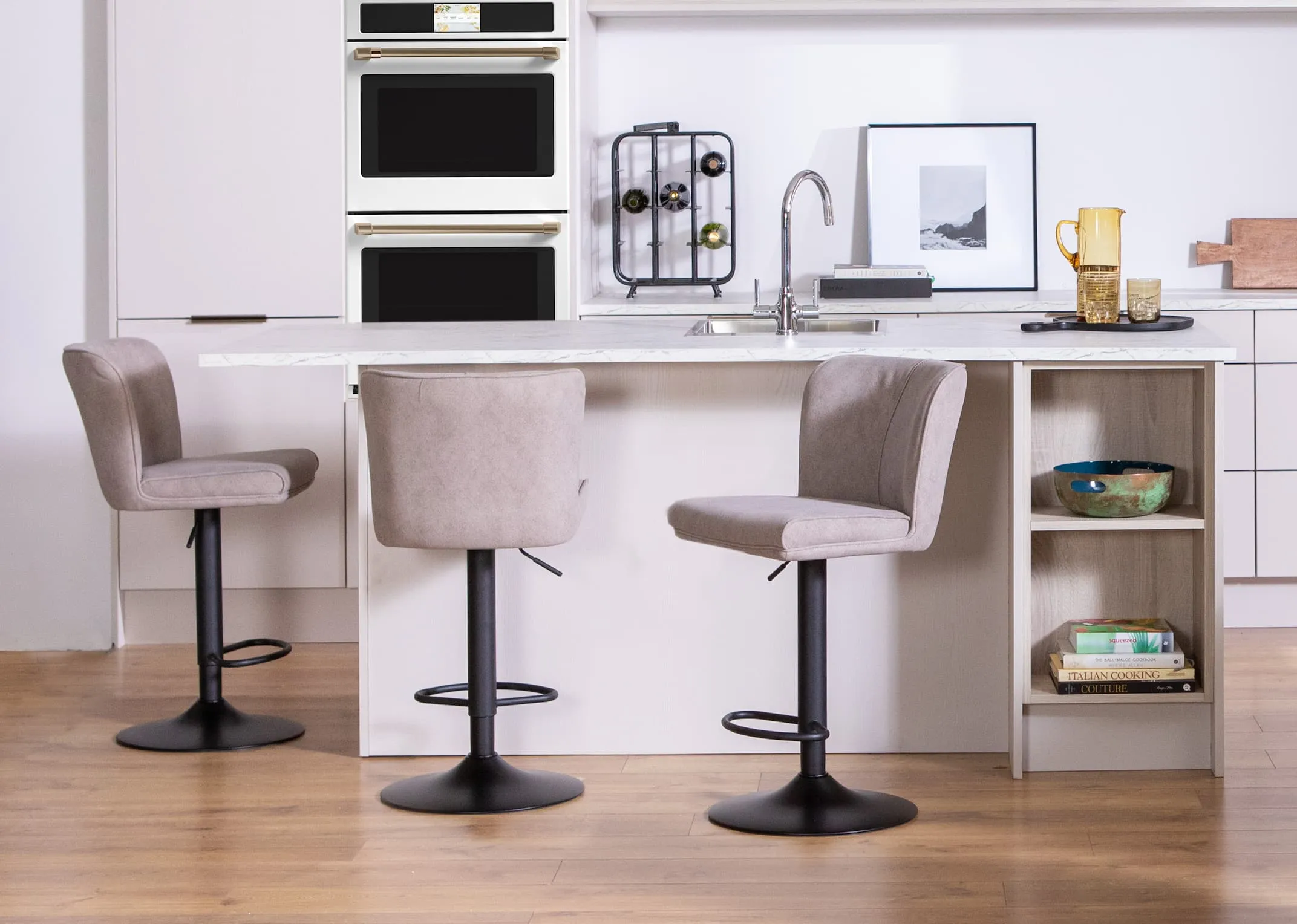 A lifestyle image of three Maple grey barstools at an island in a kichen setting.