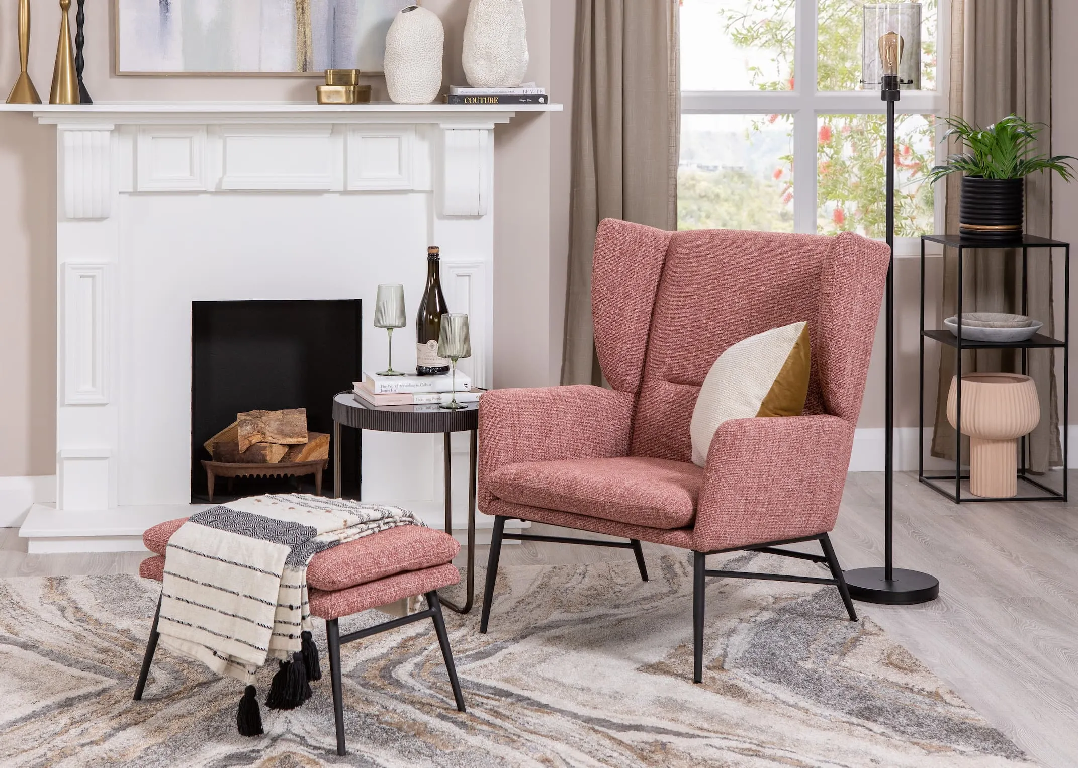 A lifestyle image of the Boston pink chair & footstool with Aruba rug and mandy side table with leanne floor lamp