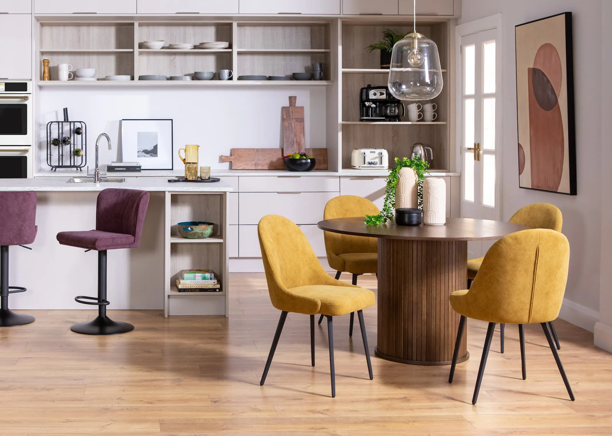 A lifestyle image of the Nola dining table with Jacob yellow dining chairs & purple bar stools