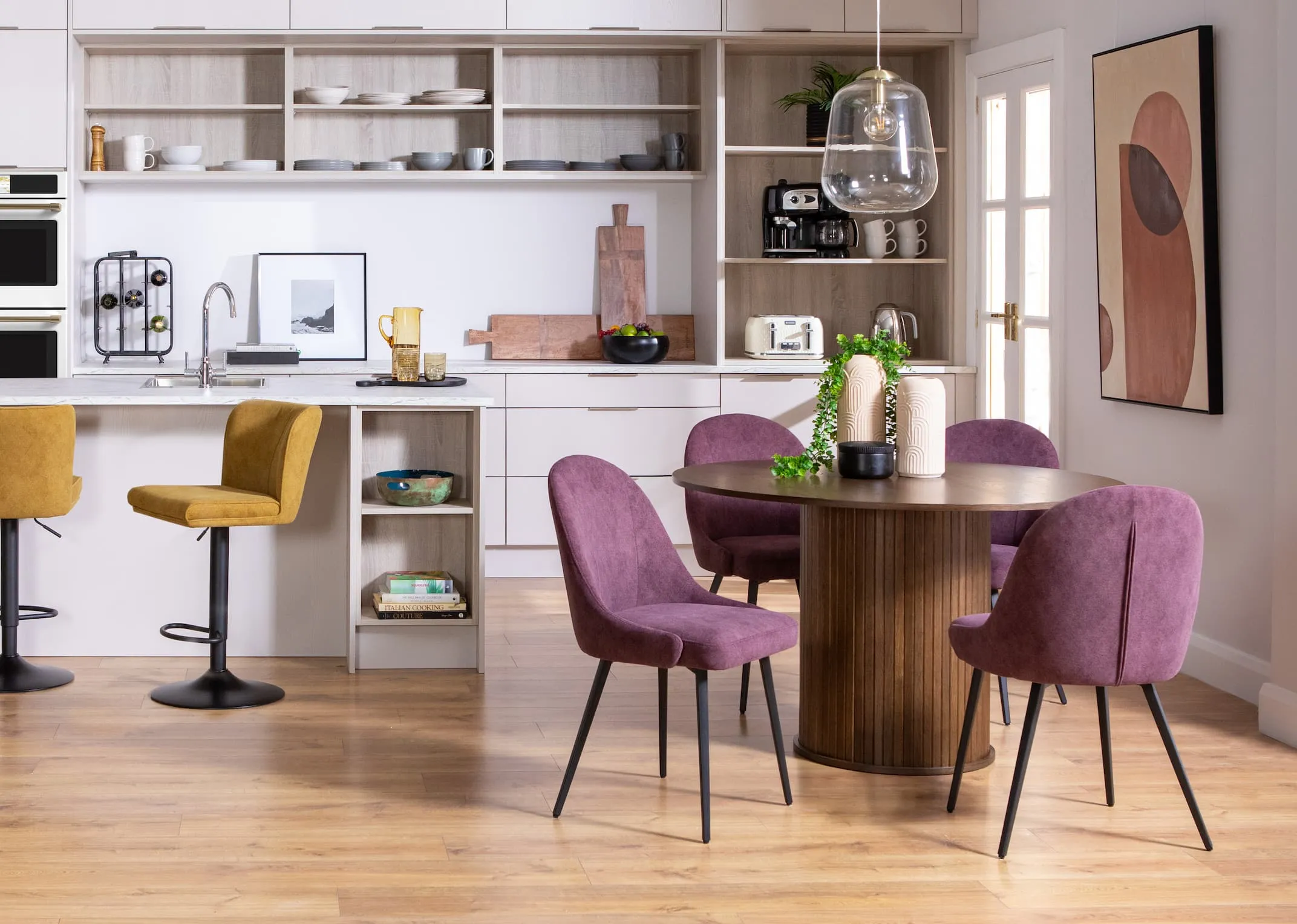 A lifestyle image of the Nola dining table with Jacob purple dining chairs & yellow bar stools.