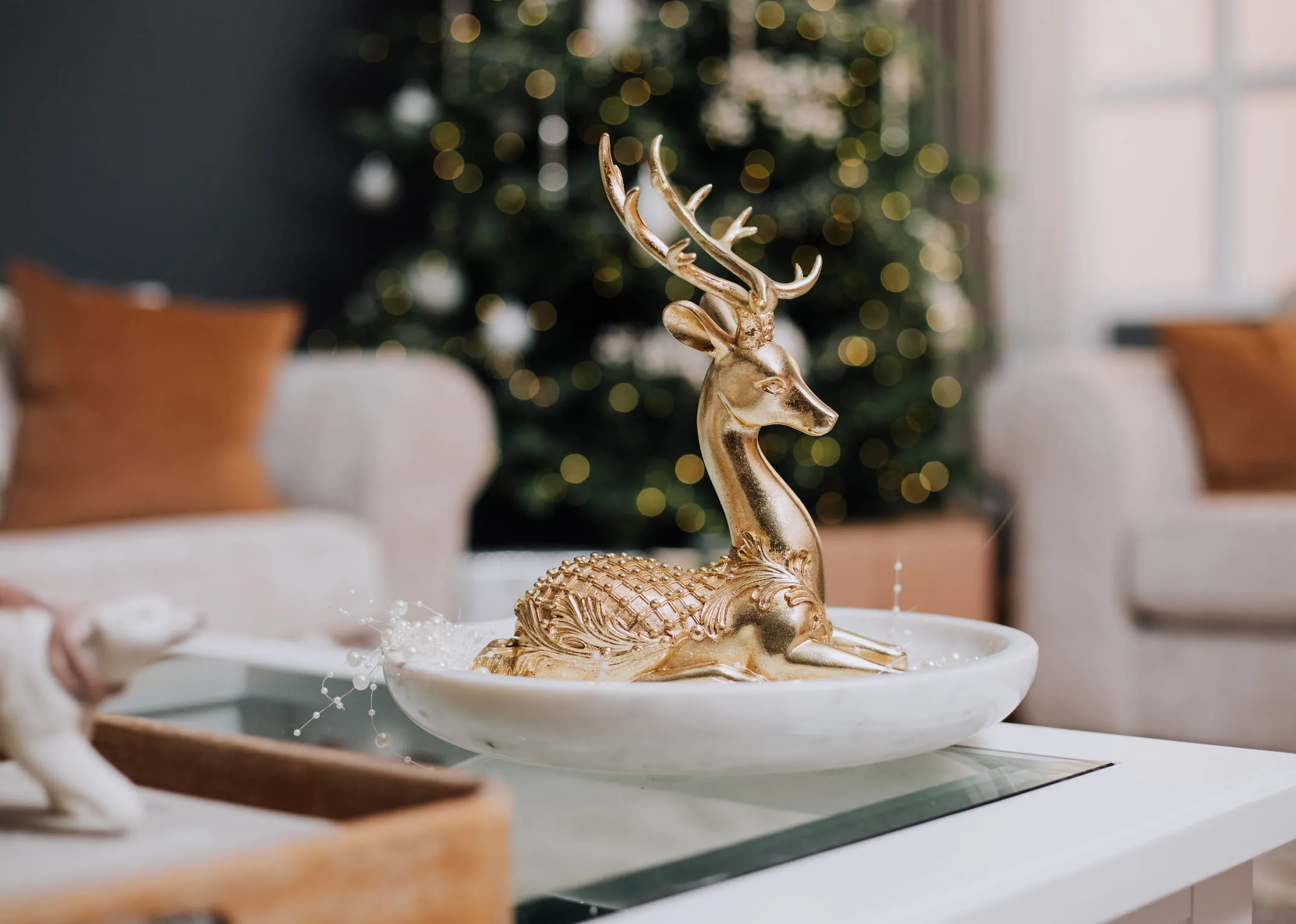 A lifestyle image of the Lying Gold Deer on a coffee table in a dish.