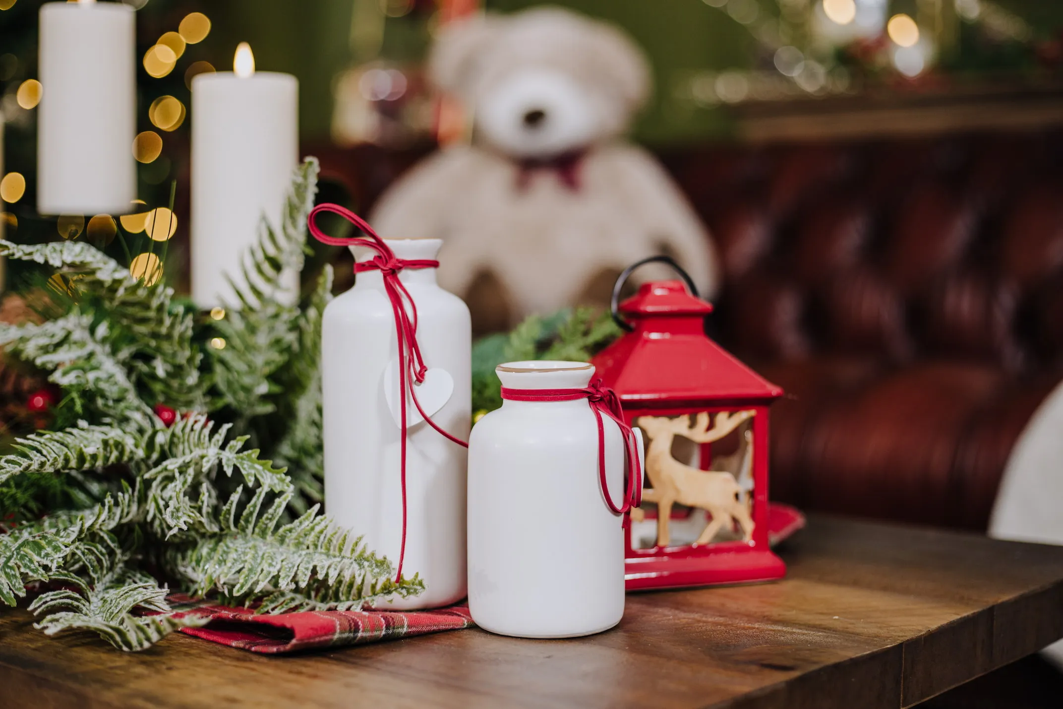 A lifestyle image of the Red Christams lantern with 2 sizes of white vase.