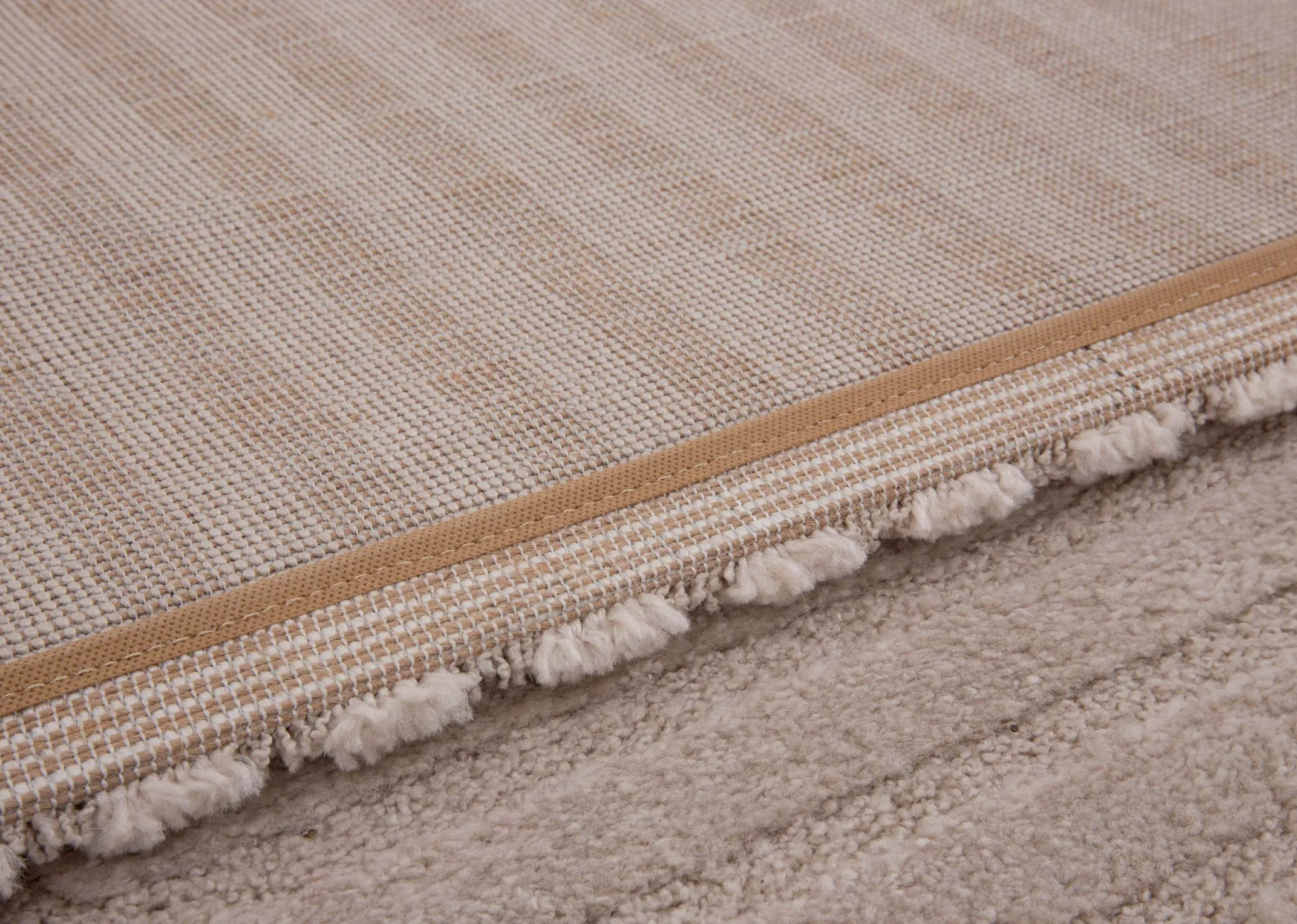 A beige & cream geometric design rug from EZ Livings Elio range. Closeup of underlay
