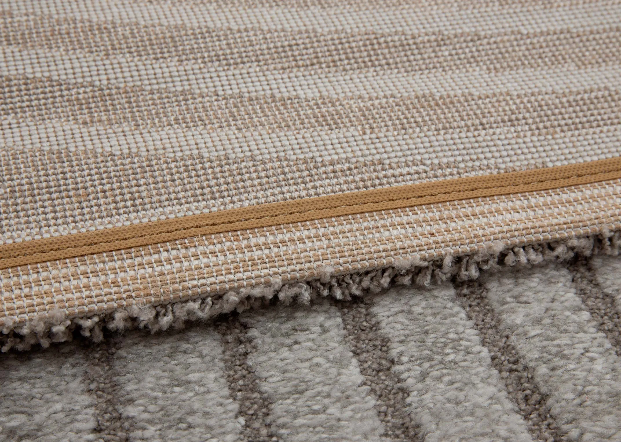 A grey geometric design rug from EZ Livings Eli range. Closeup of underlay