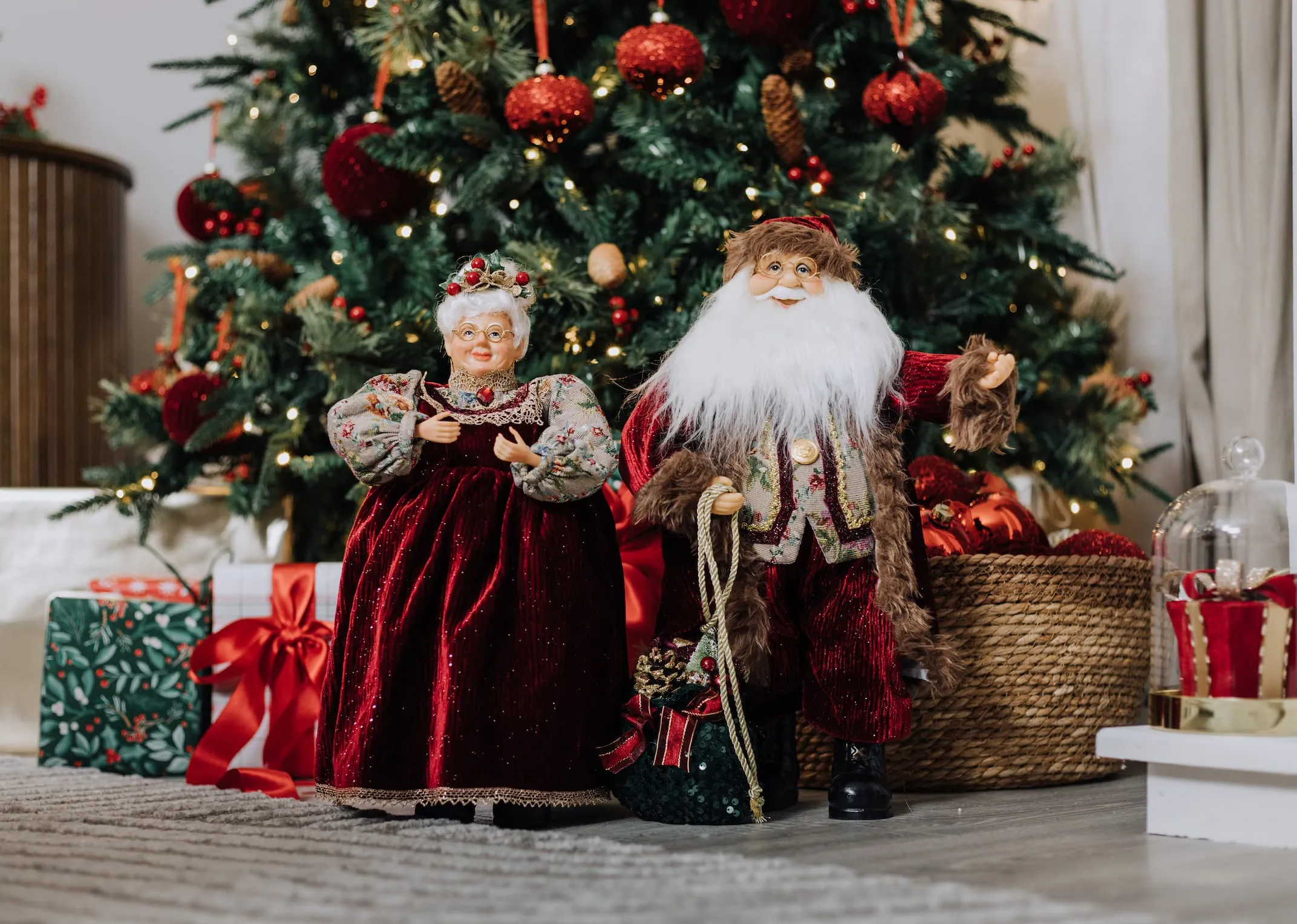 A lifestyle image of the Mr & Mrs Santa under a Christmas tree.